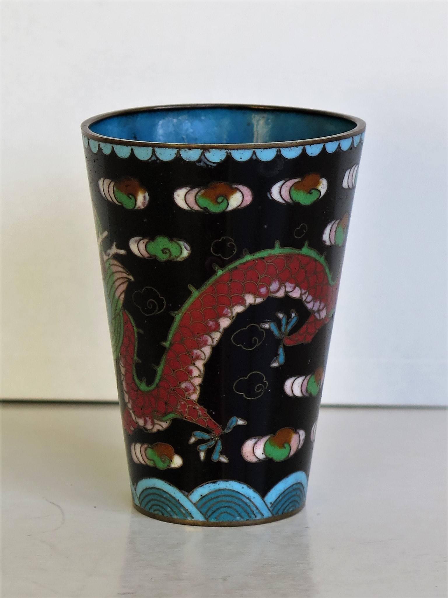 This is a very attractive Chinese Cloisonné beaker that we date to the early 20th century of the late Qing dynasty.

The beaker has a good tactile tapered shape.

The decoration shows a mythical four clawed dragon chasing a flaming pearl through