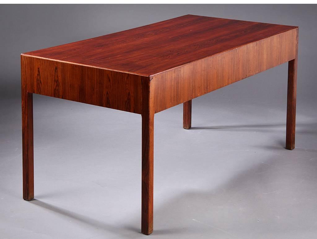 Measuring L.148 cm B. 72 cm H. 73 cm, this Danish modern rosewood desk is most likely a unique piece make by a cabinetmaker for a private client. Acquired in Denmark, this piece combines early 20th century detailing (such as beading to drawers) with