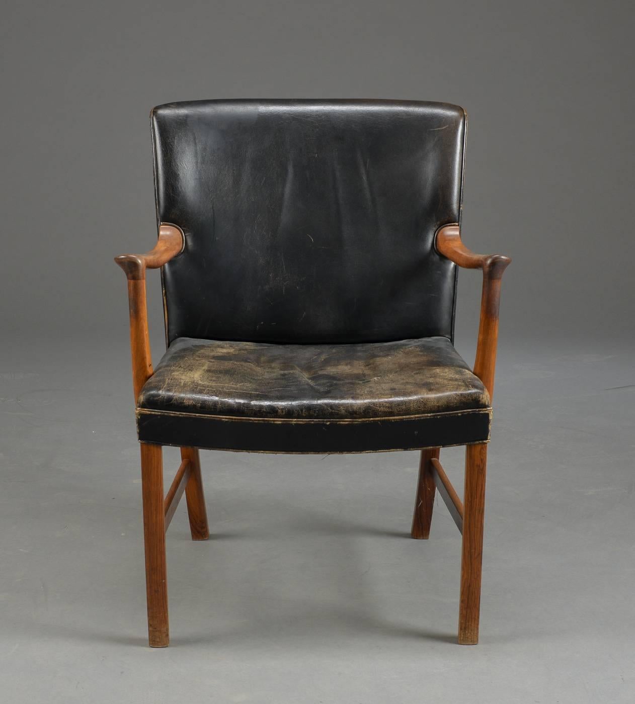 Designed by Ole Wanscher for AJ Iversen, this chair with rosewood frame and original black leather was made in the 1950s-1960s in Denmark. The frame is in excellent condition. The leather shows normal signs of age and use.