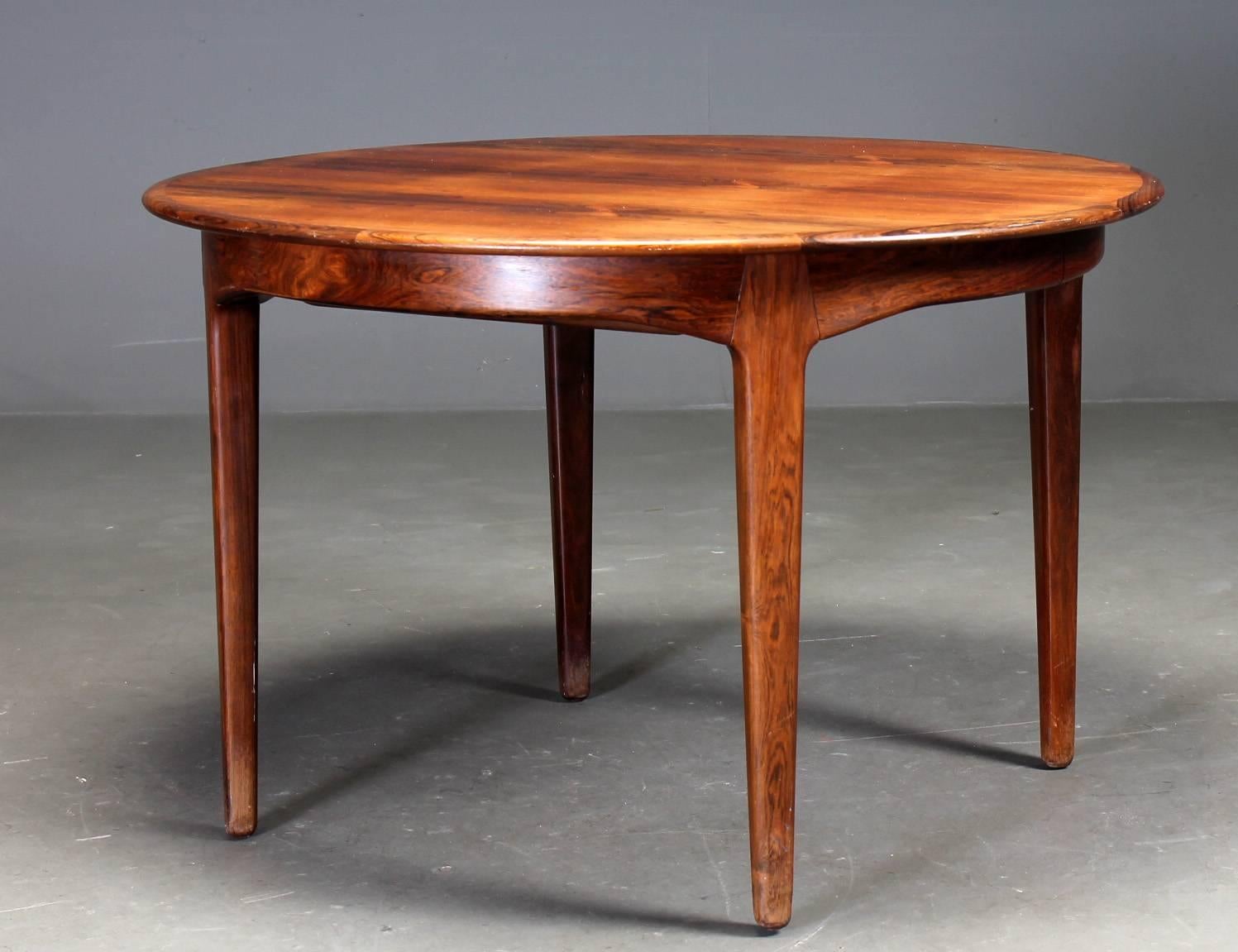 This round dining table extends to 275 cm was designed by Henning Kjaernulf in 1958 and made and labelled by Soro. The construction is extremely robust with each solid rosewood led sliding into slots in the apron of the table. This interlocking