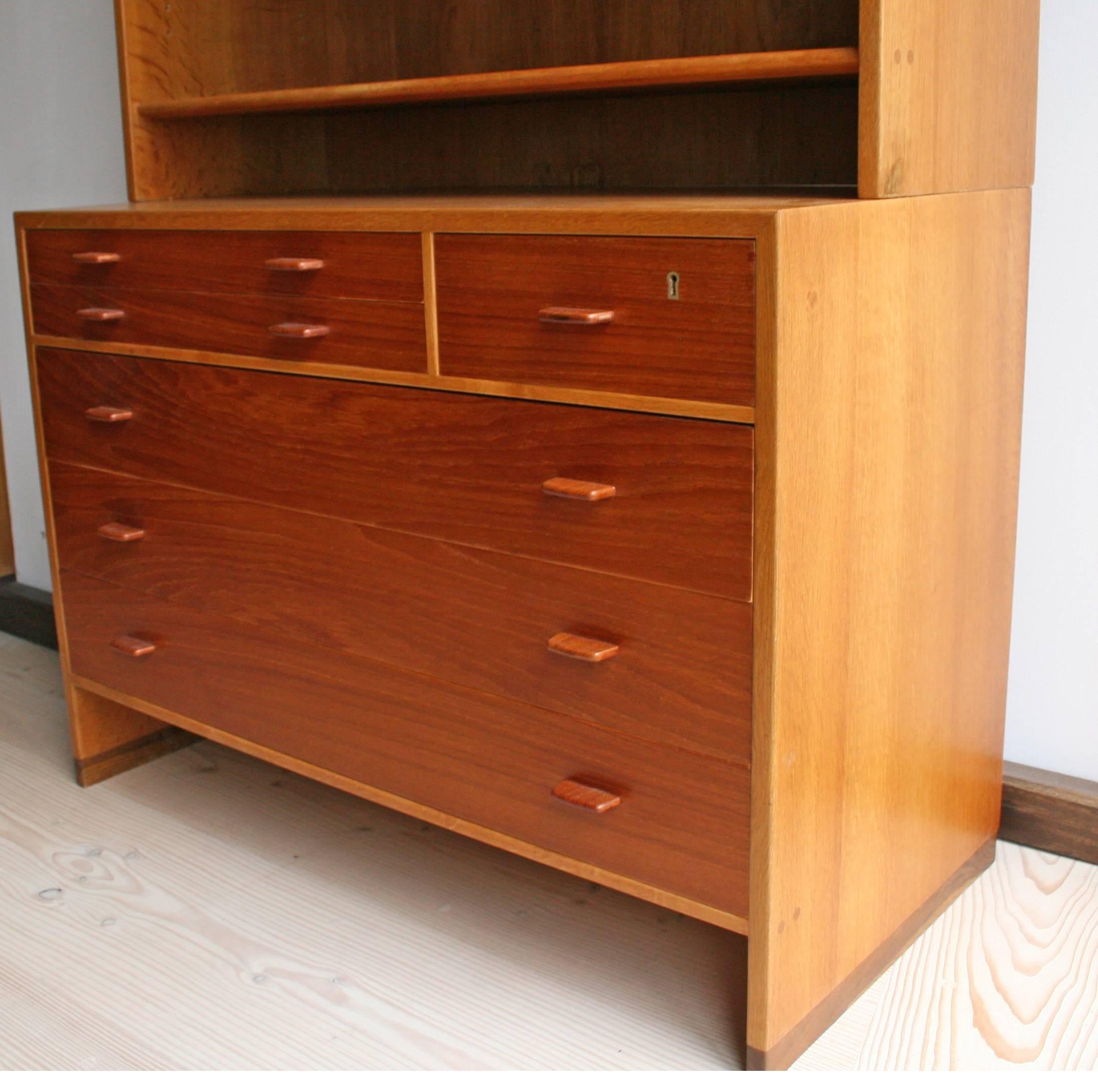 This teak chest of drawers with bookcase or shelving unit above was made 1950s-170s in Denmark. The shelves are adjustable. The piece has been re-polished and a 2x2 inch veneer patch has been restored as shown in picture.