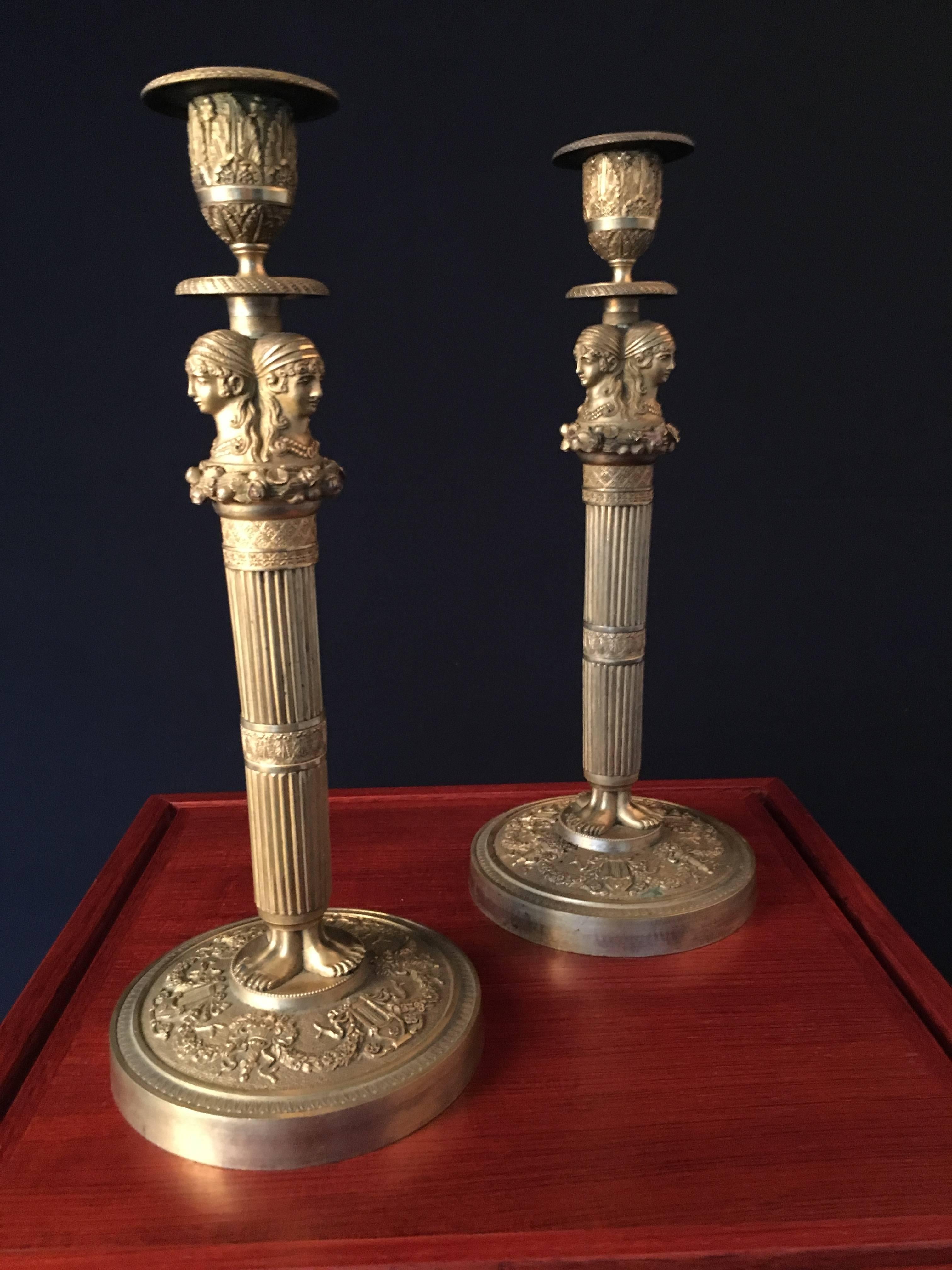Pair of gilded and sculpted bronze candlesticks from the Empire period.
Beneath the socket, three female busts face outward, the foot of the barrel is decorated with three sets of feet on a circular base.
Sculpting is of very high quality, and