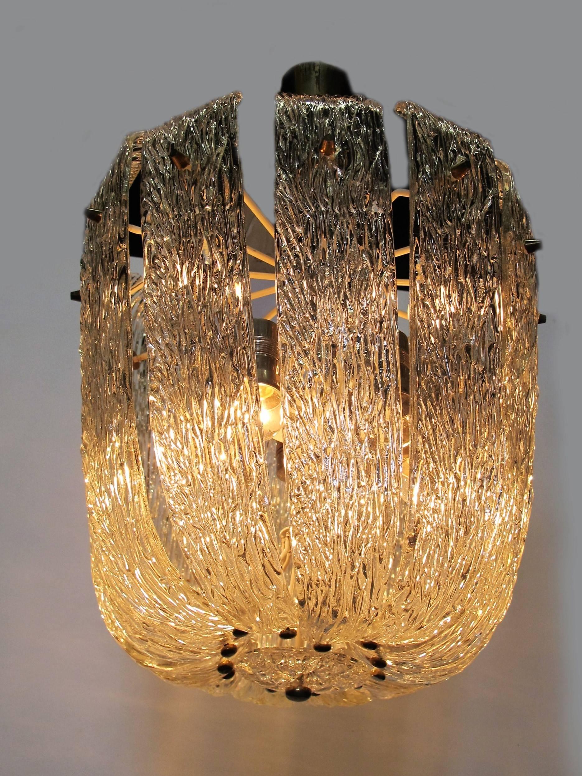 Impressive chandelier by the Austrian armature designer J.T. Kalmar, Vienna. The lamp is composed of elegantly curved and textured clear glass with brass detailing.

The lamp is in excellent condition with working lights.

Height of whole lamp: 65