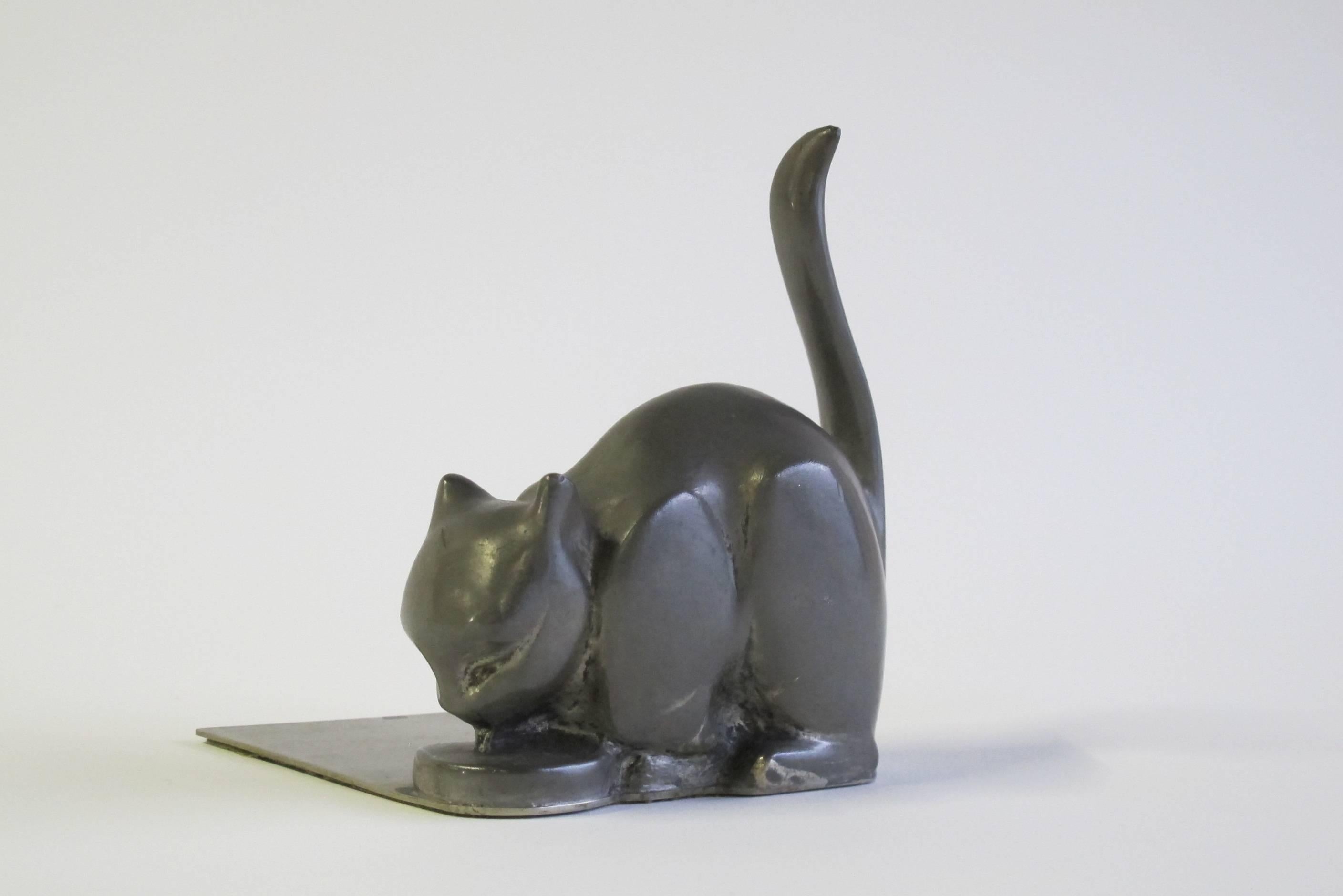 Two lovely Art Deco bookends, designed by Chris van der Hoef for Gero in Zeist. The tin bookends show two cats drinking from their bowls. The bookends are both marked with the manufacturers mark at the end of the plates and monogrammed with the