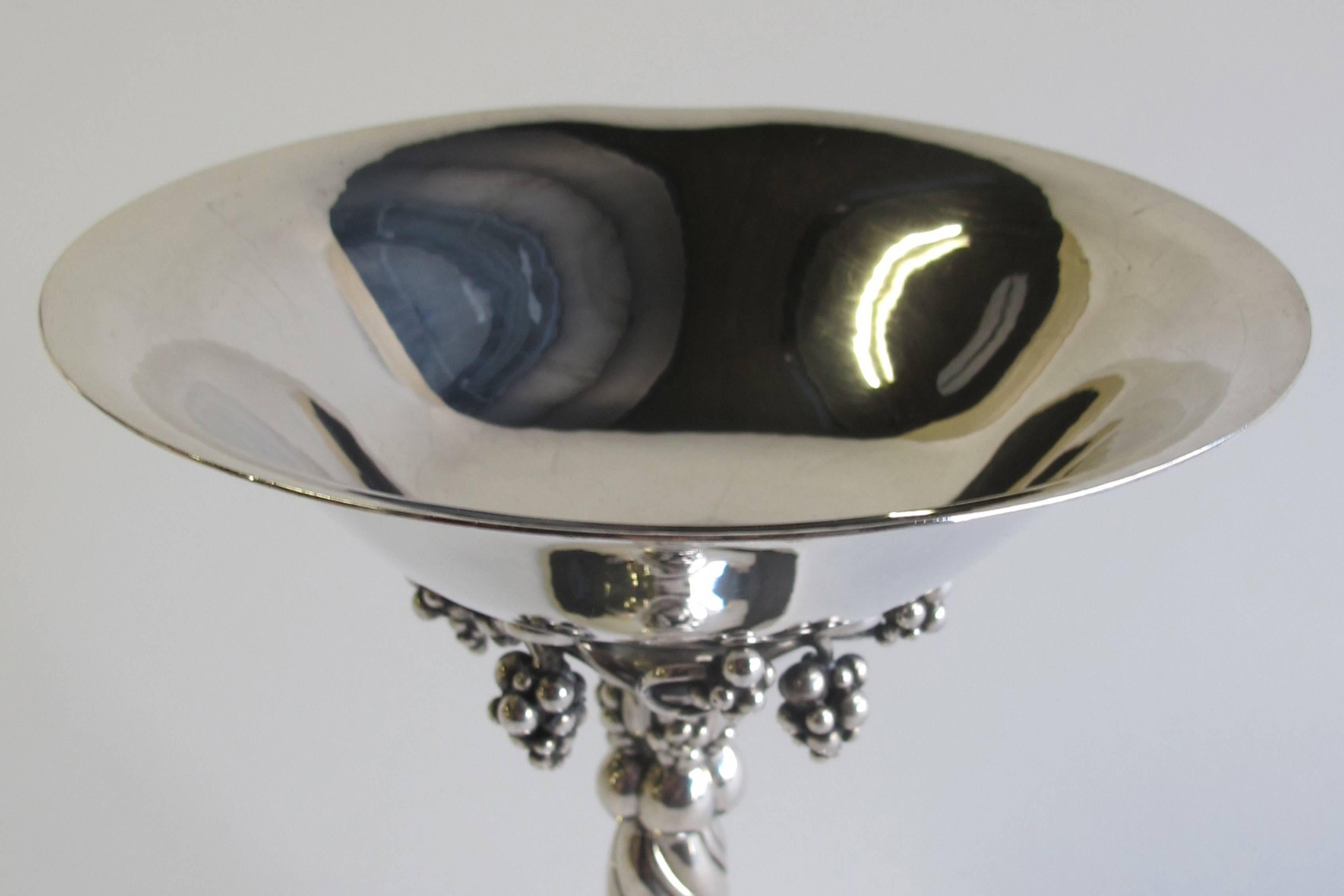 Gorgeous hammered sterling silver tazza with grapes (model no. 263) designed by Georg Jensen in 1918. The compote has a spiral fluted stem and a circular foot.

This particular tazza was once engraved for an anniversary. This inscription reads 'Fra