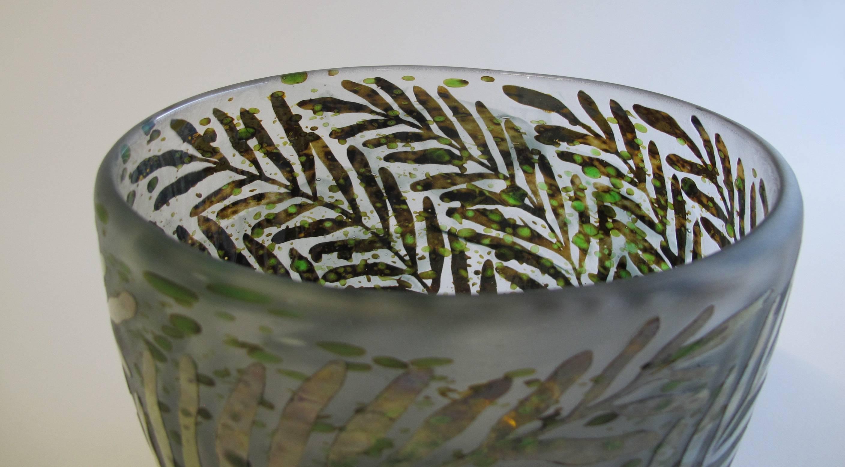 Gorgeous glass vase designed by Heikki Orvola and manufactured at Nuutajärvi Notsjo. The vase has an etched pattern with leaves all-over the surface. The outside of the vase shows a matted surface and the leaves have an almost oily shine. The inside