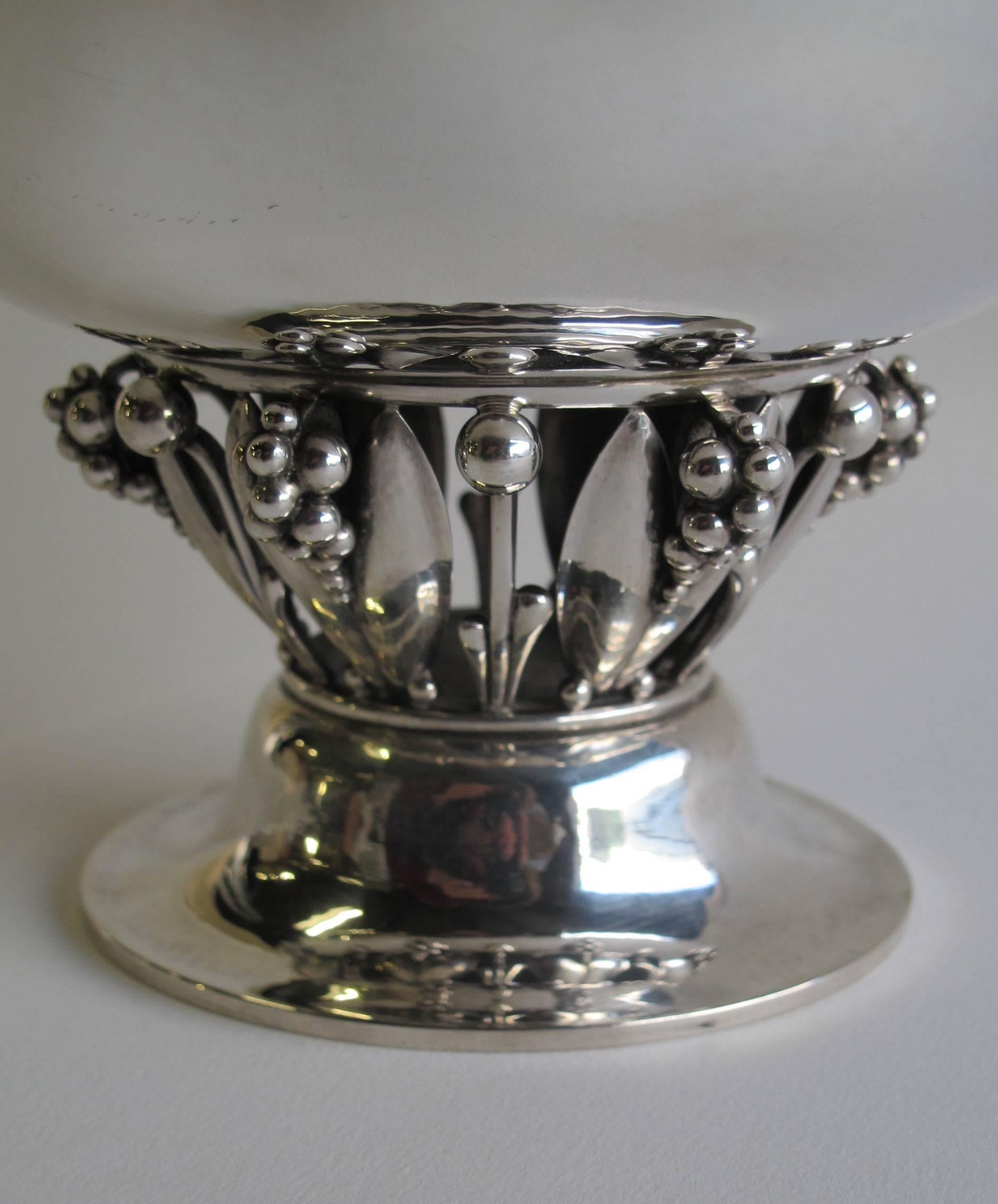 Outstanding hammered sterling silver centerpiece designed by Georg Jensen in 1916. The bowl rests on an openwork stem with leaves an grapes and a circular foot. The number of this design is 197a. The piece is executed between 1945-1951.

The