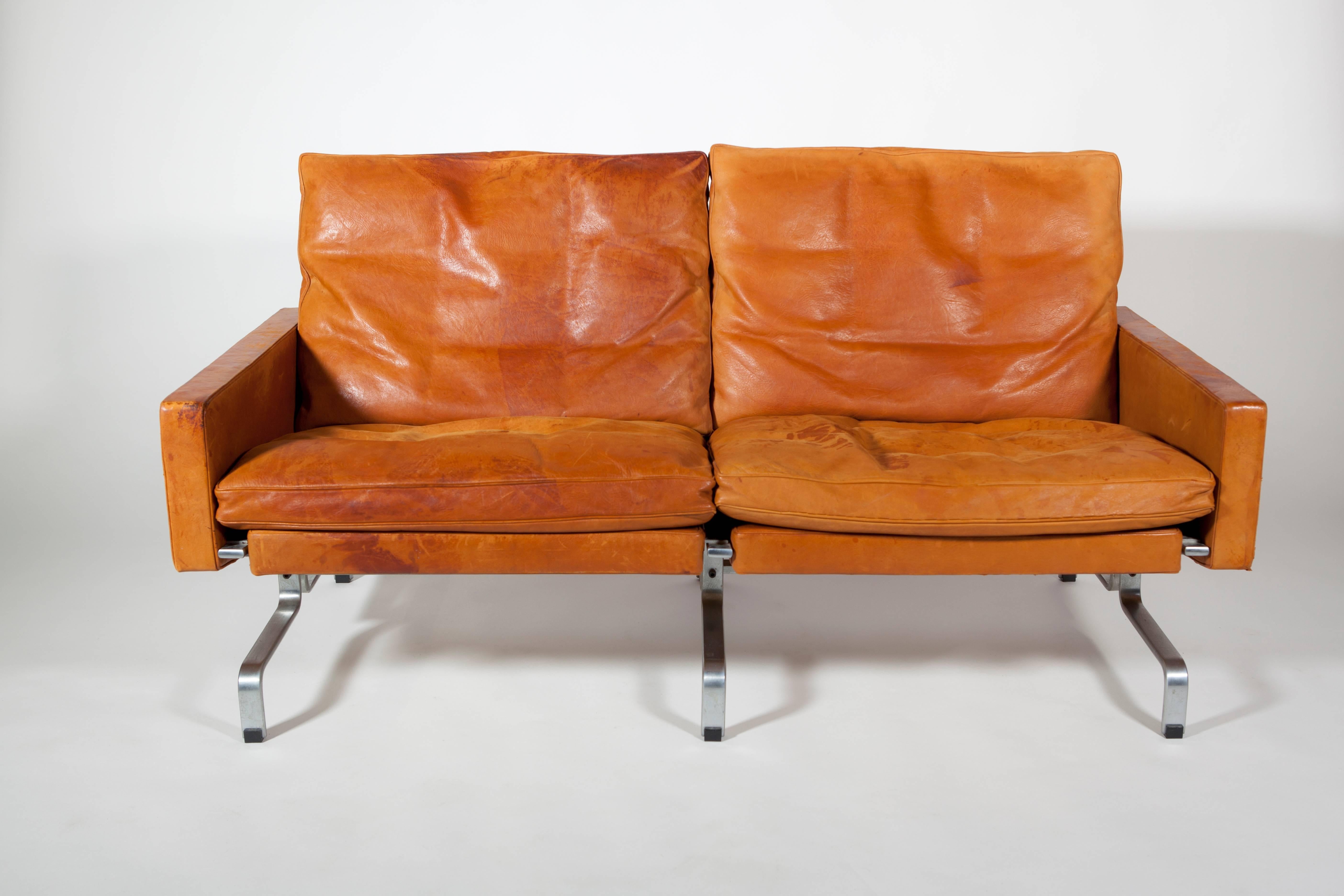 This vintage steel and leather sofa, model PK31/2, is an early Industrial Design of Danish designer Poul Kjaerholm. This sofa was part of the rare first series produced by E. Kold Christensen, shortly after 1958. The sofa has been used as it was