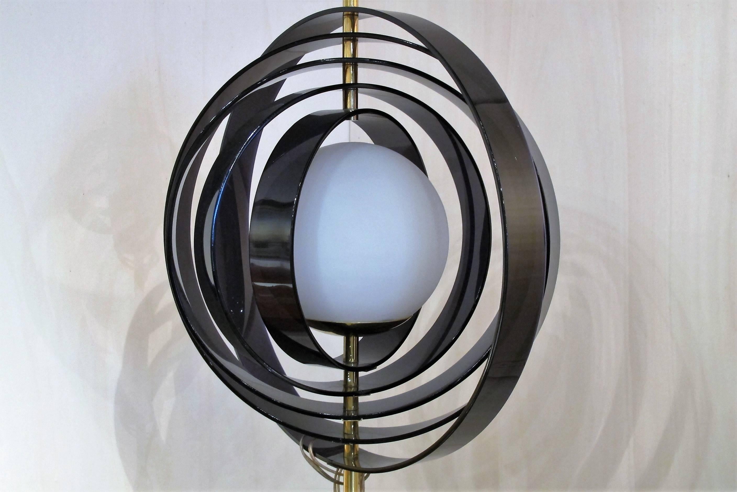 A beautiful floor lamp by Stilux Milano, made of black lacquered metal and brass. The glass spherical lamp-shade is surrounded by five black/ dark purple colored plastic slats, on a white marble base.