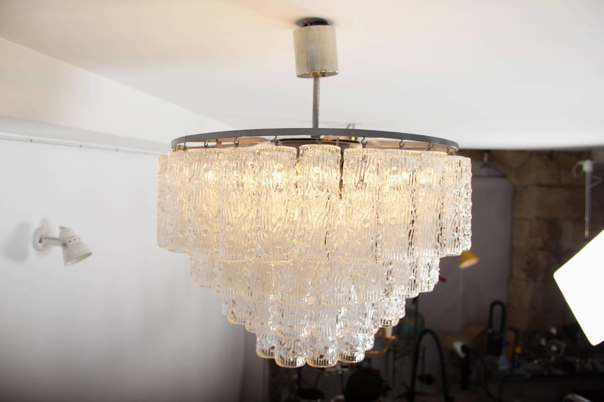 Designed by Paolo Venini and produced in the 1960s by Venini, this ceiling lamp in perfect condition consists in 74 texturized clear glass pieces. Each Murano glass piece is 15 cm in length and weights circa 250 gr. The electrical wiring is in good