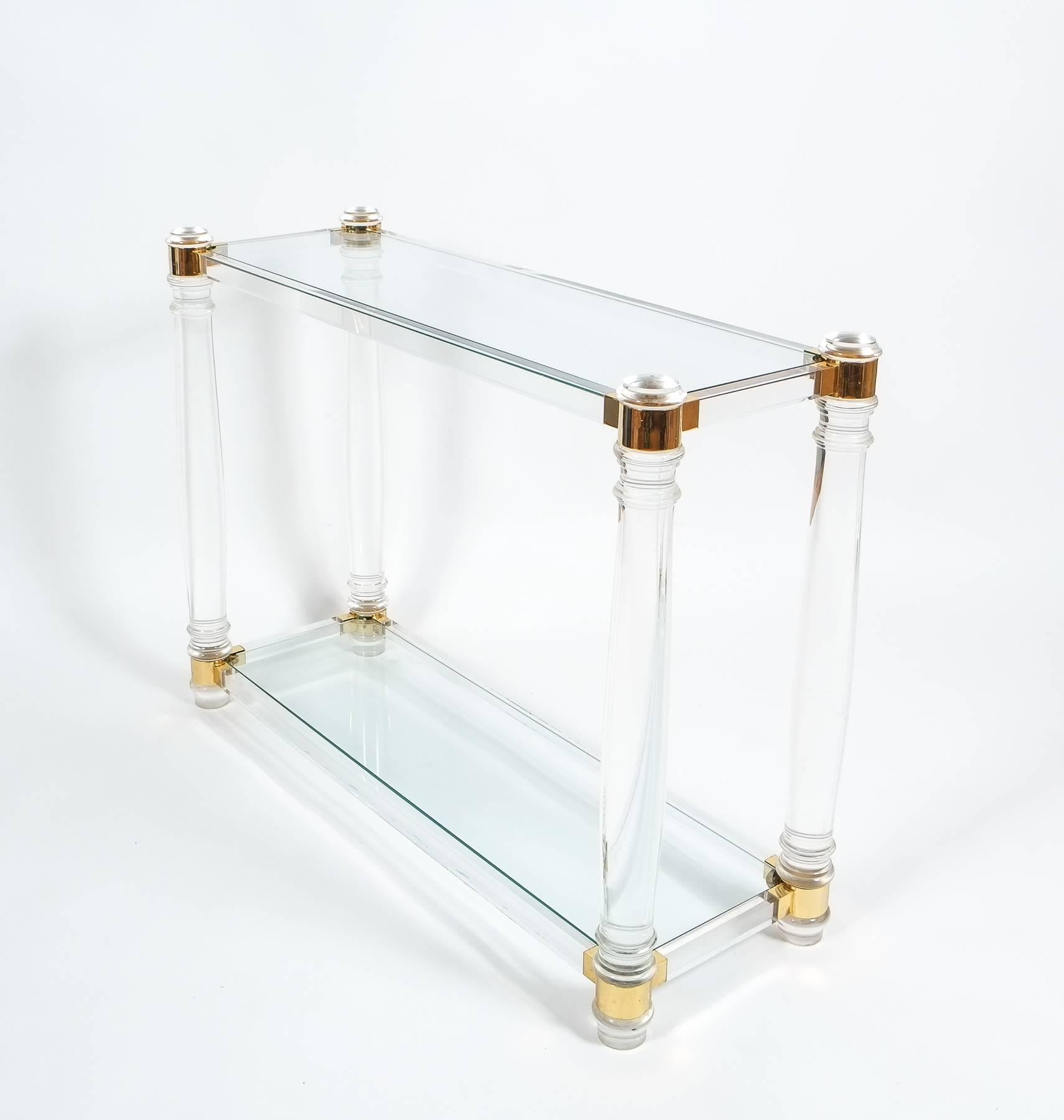 Classical console table by Romeo Rega consisting of round Lucite pillars and gilt brass joints. Two clear glass trays. The table is in excellent condition, minimal traces of use and some small chips on the glass.