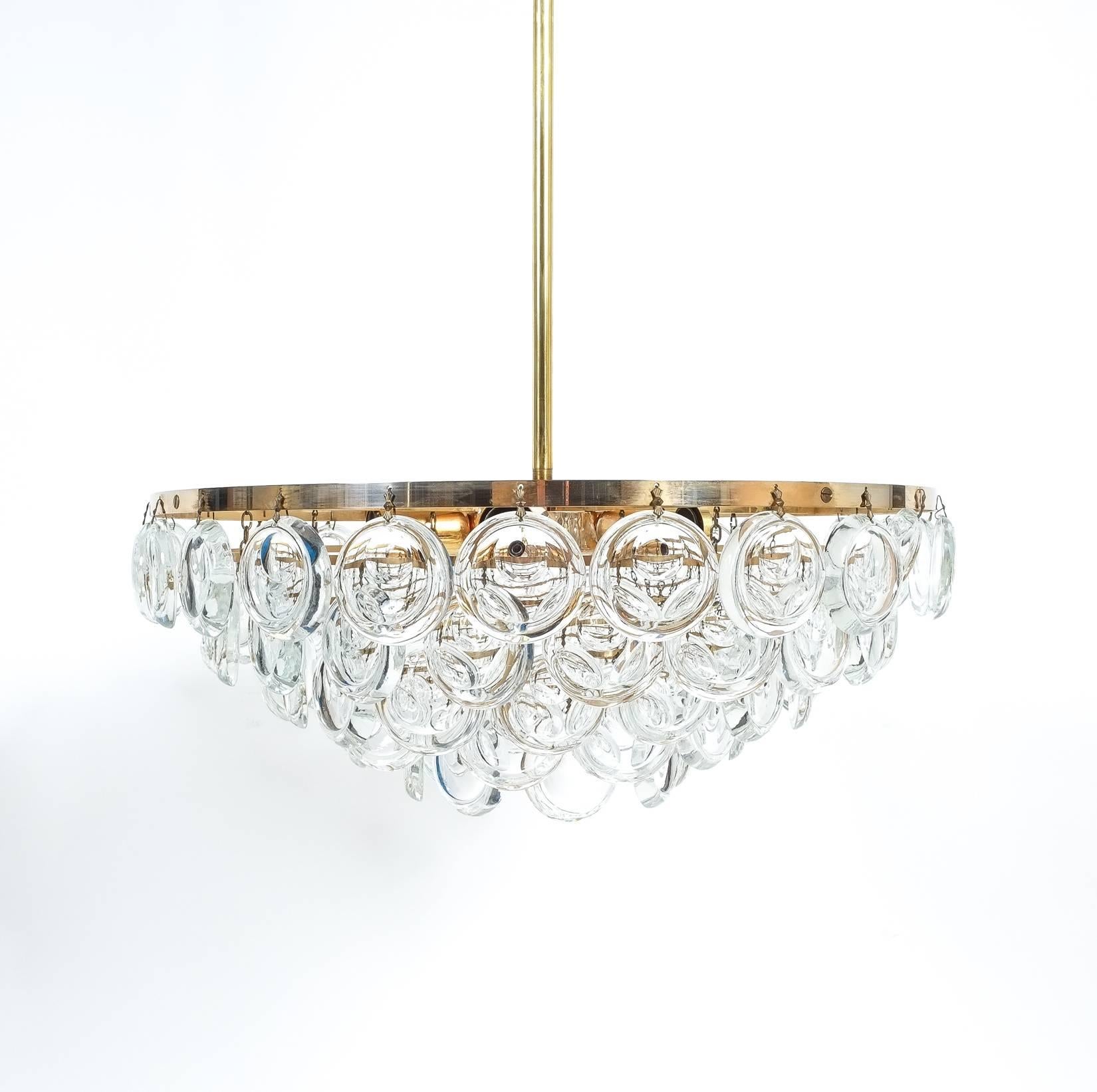 Elegant chandelier by Sciolari, Italy, circa 1960.This piece features smooth jewel like optical crystals and polished brass rings. It holds six bulbs (E14 with 60W max) and has been professionally cleaned and rewired (US + EU) and is in excellent