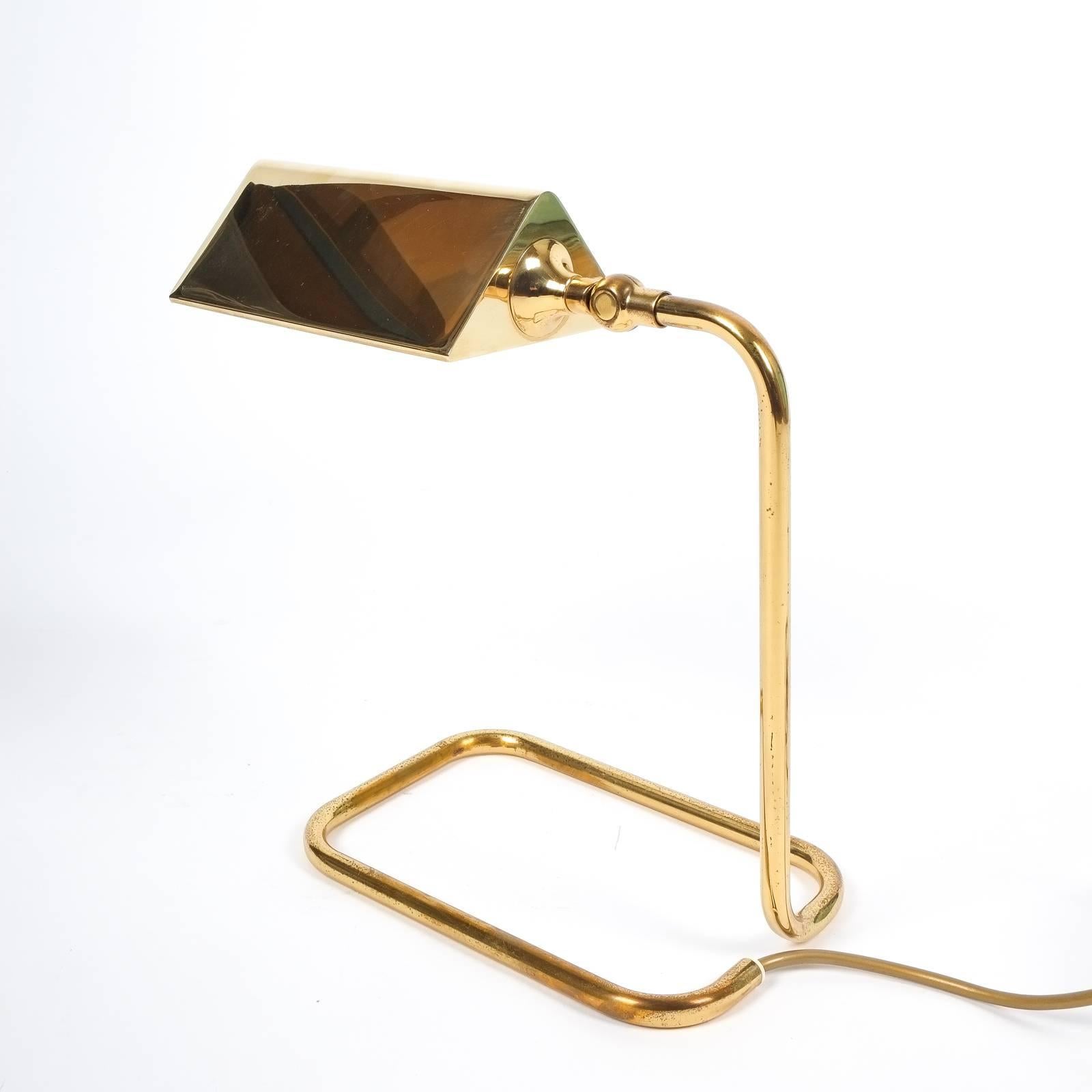 Nice table light by Koch Lowy, circa 1960 featuring a bent brass base and polished brass shade. It holds a single large bulb with 60W maximum and is in excellent condition.