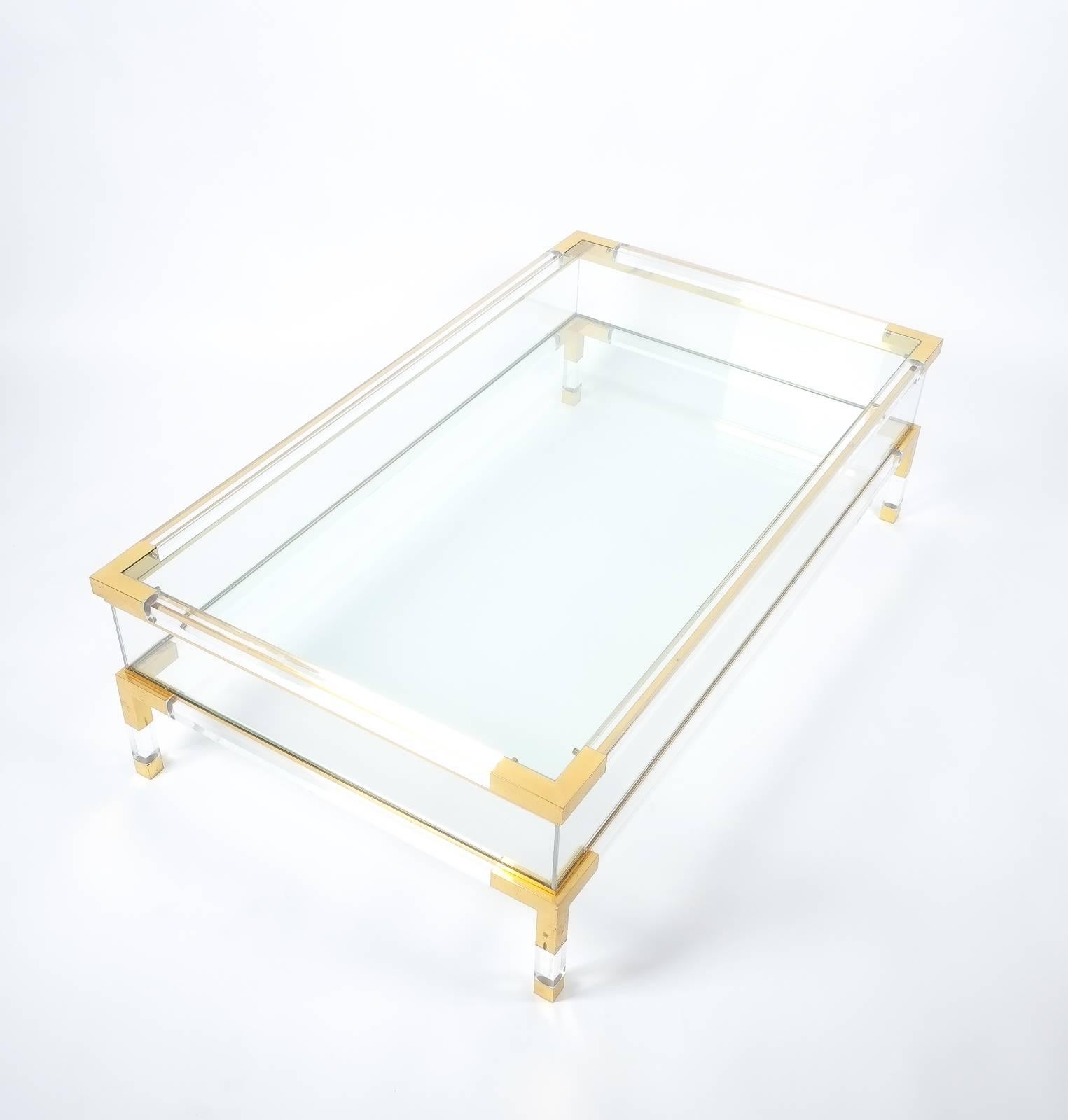 Beautiful coffee table by Maison Jansen, 1970, France, featuring polished Lucite elements with brass joints and glass tops. The top can slide open to reveal an inside compartment for books or decoration. The condition is excellent with a beautifully