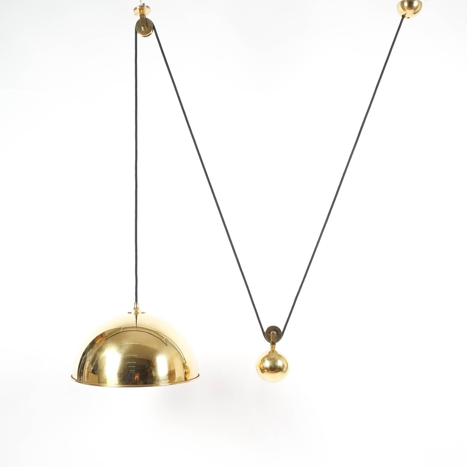 Elegant newly polished brass pendant light by Florian Schulz/Germany with a shiny brass 14.7 inch shade and heavy counterweight to easily adjust the light in height. Excellent restored condition, it holds one bulb with a maximum of 100 Watts. The