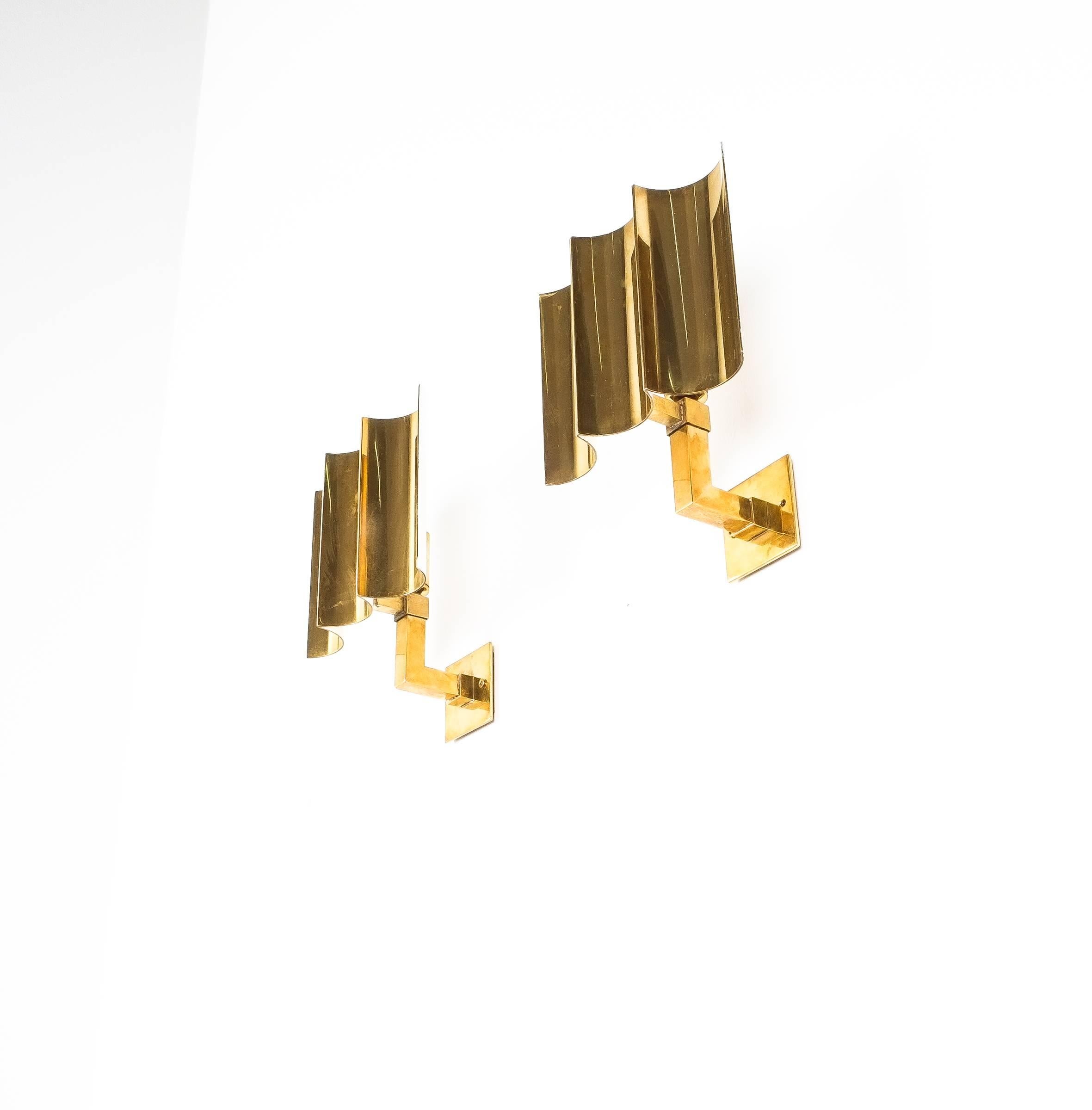 Artisan solid brass wall lamps Art Deco style, France, 1950. Very elegant handmade brass wall lights made from thick brass sheets; great craftsmanship with a single bulb per light (e14, 40W max) The lamps have been newly rewired (US +EU standards),