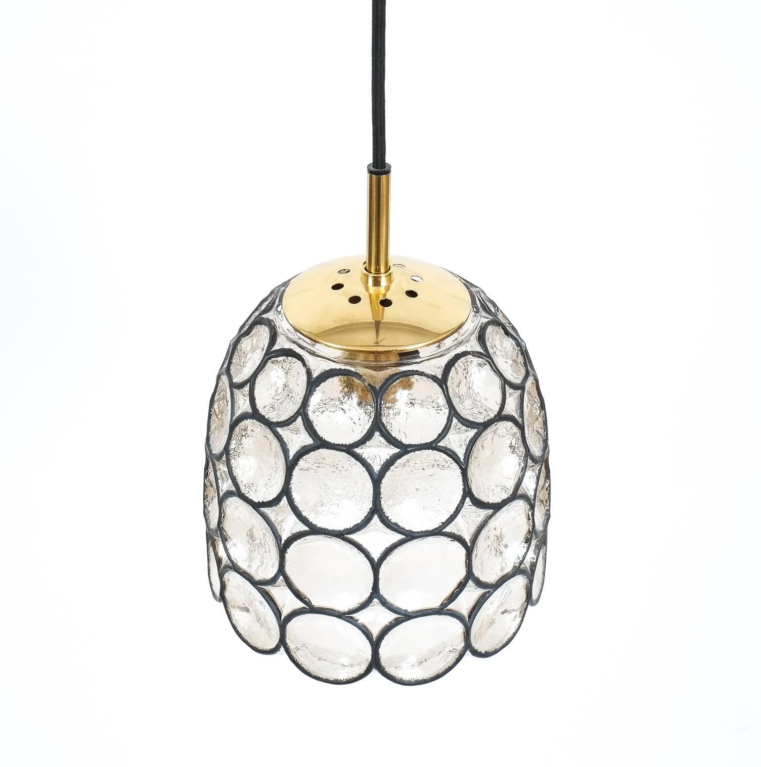 Beautiful set of three 'iron' and glass bell-shaped pendants by Limburg, Germany. These fixtures feature a concaved thick clear glass shade with circle 'iron' elements. The hardware is made from polished brass. It holds a single large bulb (100W