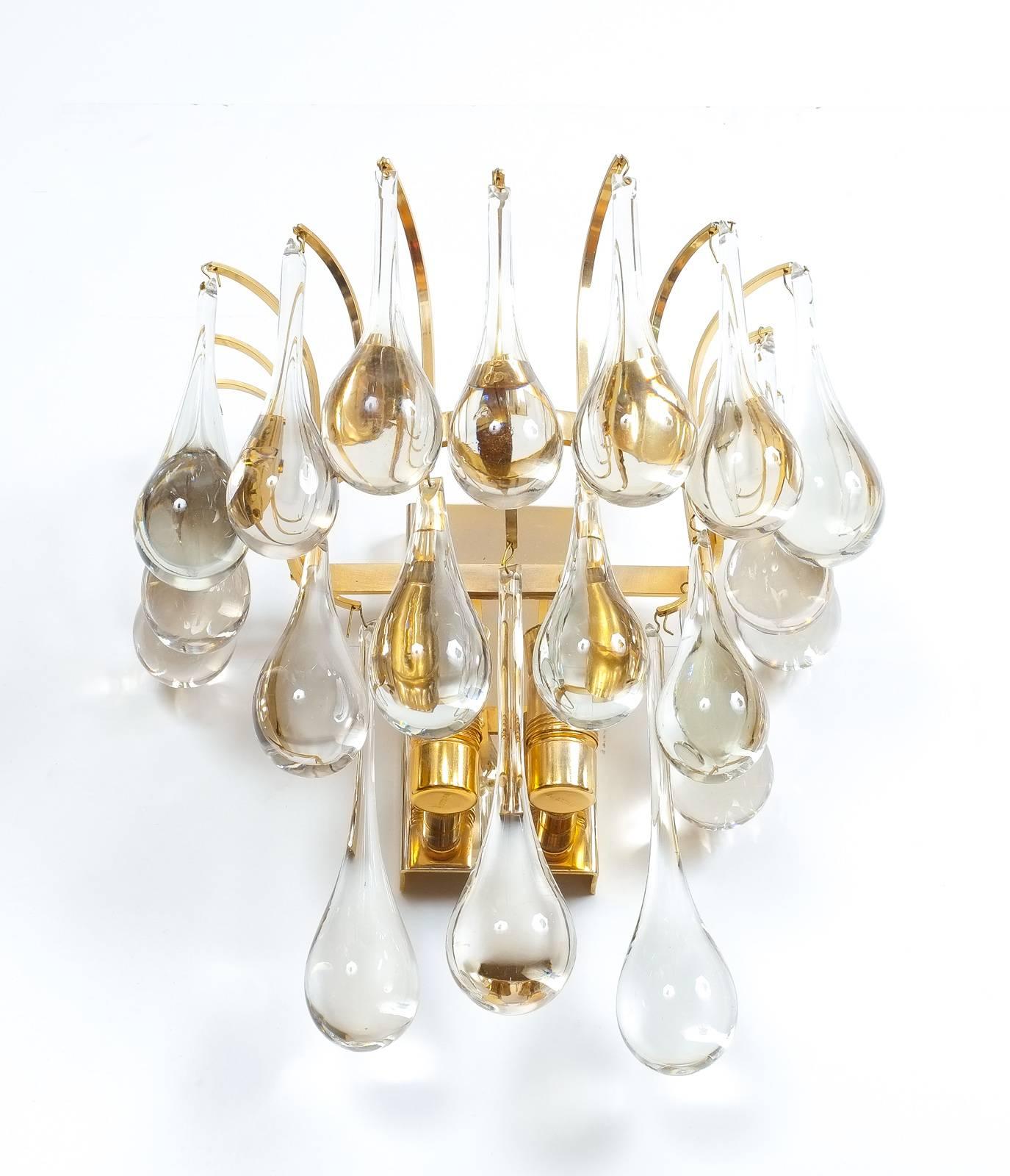 Beautiful multi-tiered pair of Murano glass tear drop sconces composed of a multitude of handblown smooth Murano glass drops hanging from a delicate gildened brass hardware. It's in excellent condition with a total of two bulbs per light. They were