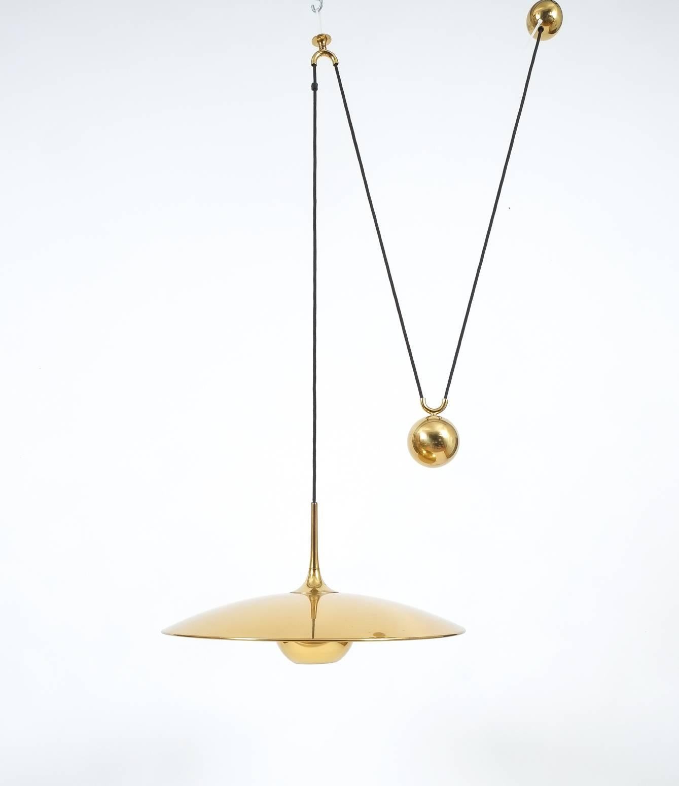 Elegant highly polished brass pendant by Florian Schulz/Germany with a shiny brass finish and heavy counterweight to easily adjust the light in height. Excellent condition, it holds one bulb with a max. of 100Watts. We have more pieces available by