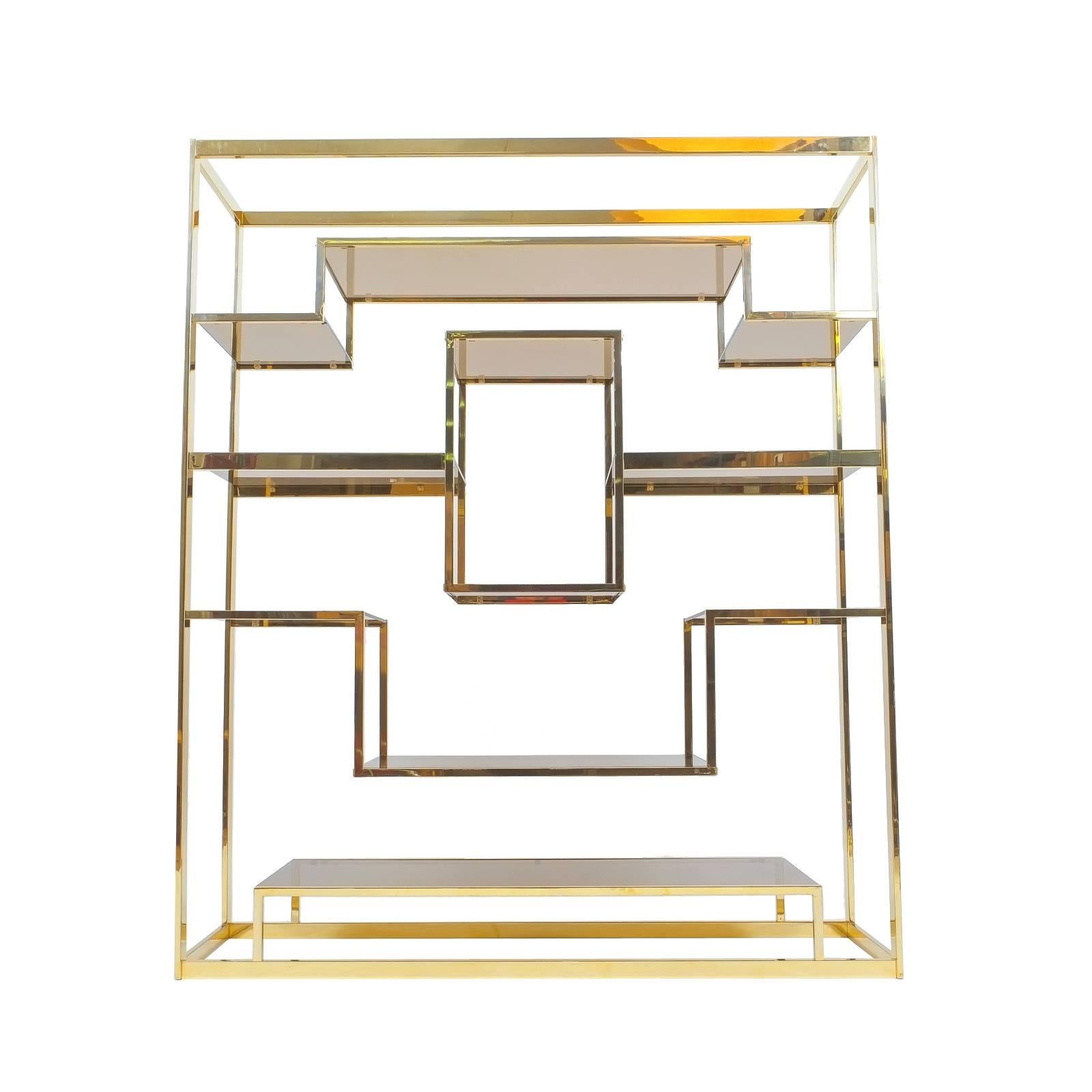 Beautiful spatial shelf by Romeo Rega, solid polished brass shelving structure with smoked glass shelves in excellent condition. Will work perfectly as a floating room divider. To visit our storefront please click on our logo /DERIVE at the bottom