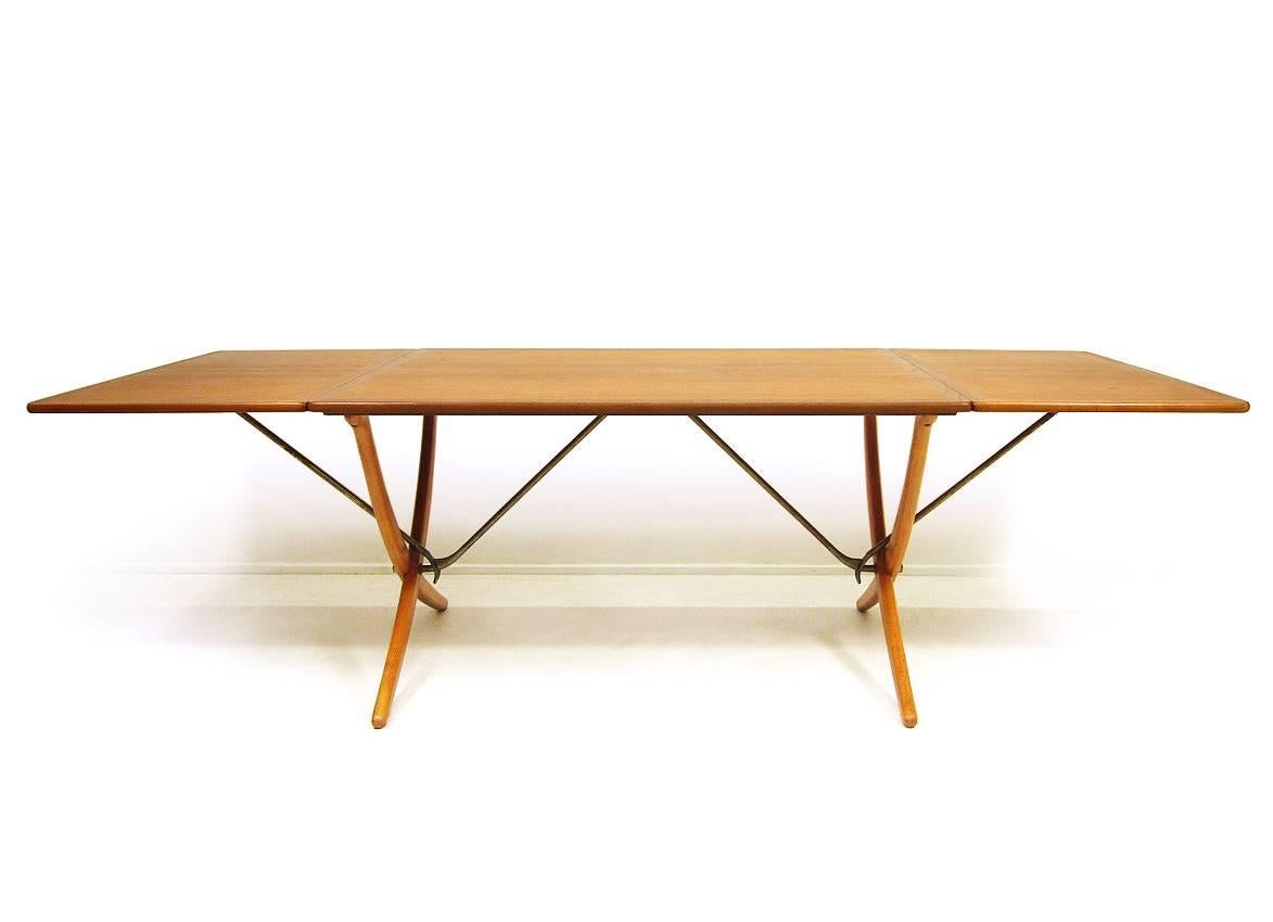 Measures: Length (fully extended): 238cm,
length (flaps down): 128cm,
width: 86cm,
height: 72cm.

A 1960s Danish "AT-304" dining table by Hans Wegner for Andreas Tuck.
 
With sabre legs in beechwood, teak surface and brass extending