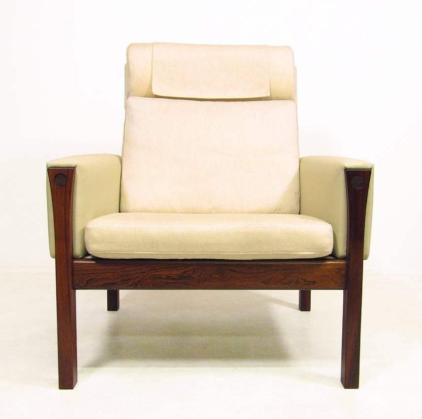 A Danish 1960s "AP-62" high back lounge chair by Hans Wegner for AP Stolen.
 
The solid rosewood frame, contoured legs and contrasting cream upholstery create a sense of mid-century luxury.
 
The arms have been re-upholstered in