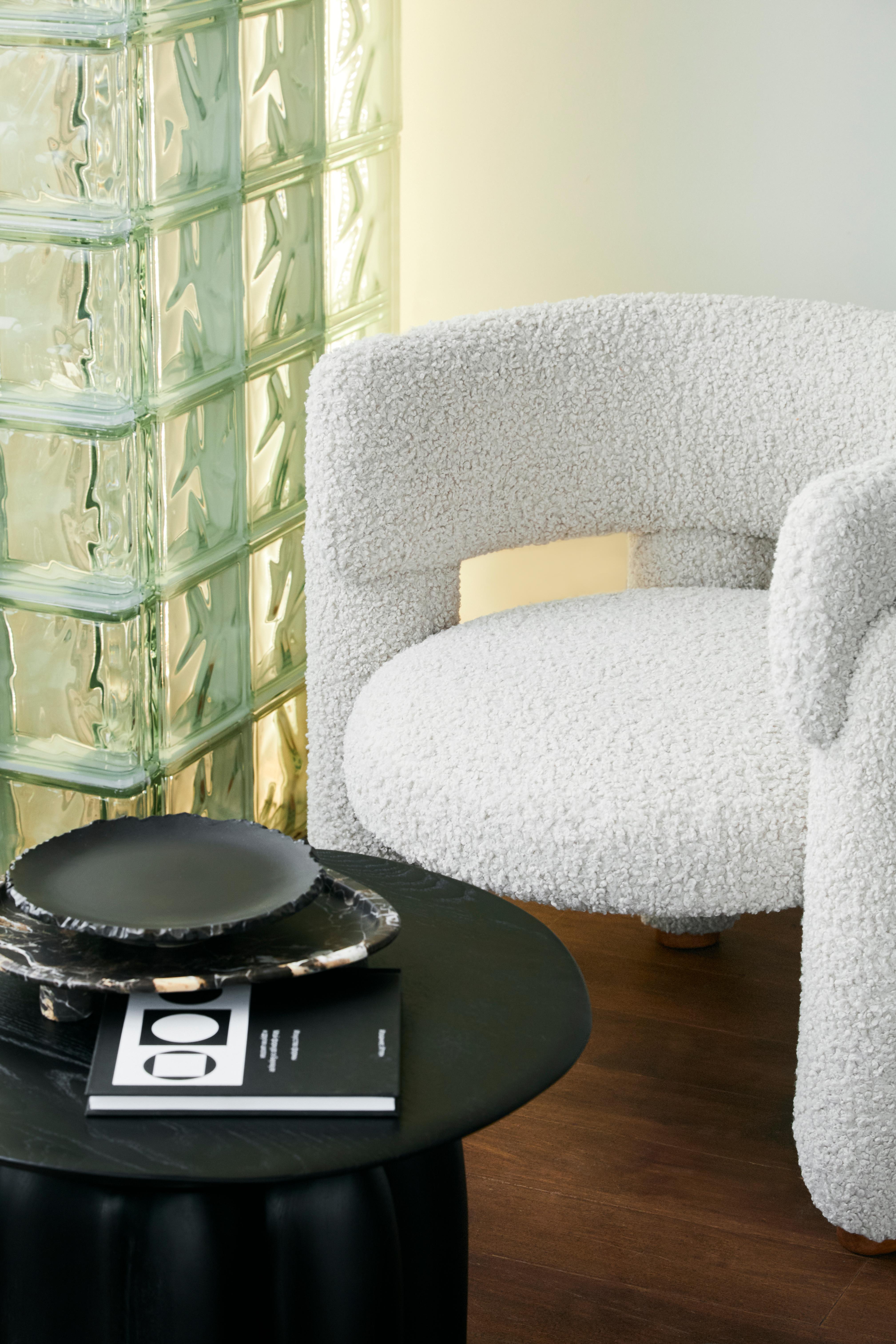 Un fauteuil au design minimaliste qui fait la part belle aux pieds volumineux. La composition est complétée par des supports en bois naturel, qui peuvent être réalisés dans la couleur du tissu ou dans une couleur contrastante.
