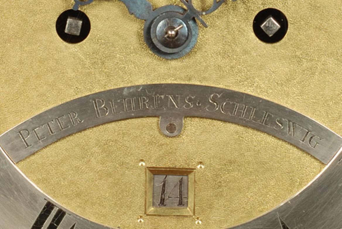 A rare German mahogany table clock of 8-day duration by Peter Behrens Schleswig, circa 1770.

20-cm arched matted brass dial, engraved silvered chapter ring with Roman numerals, foliate pierced blued hands, engraved signature plate Peter Behrens