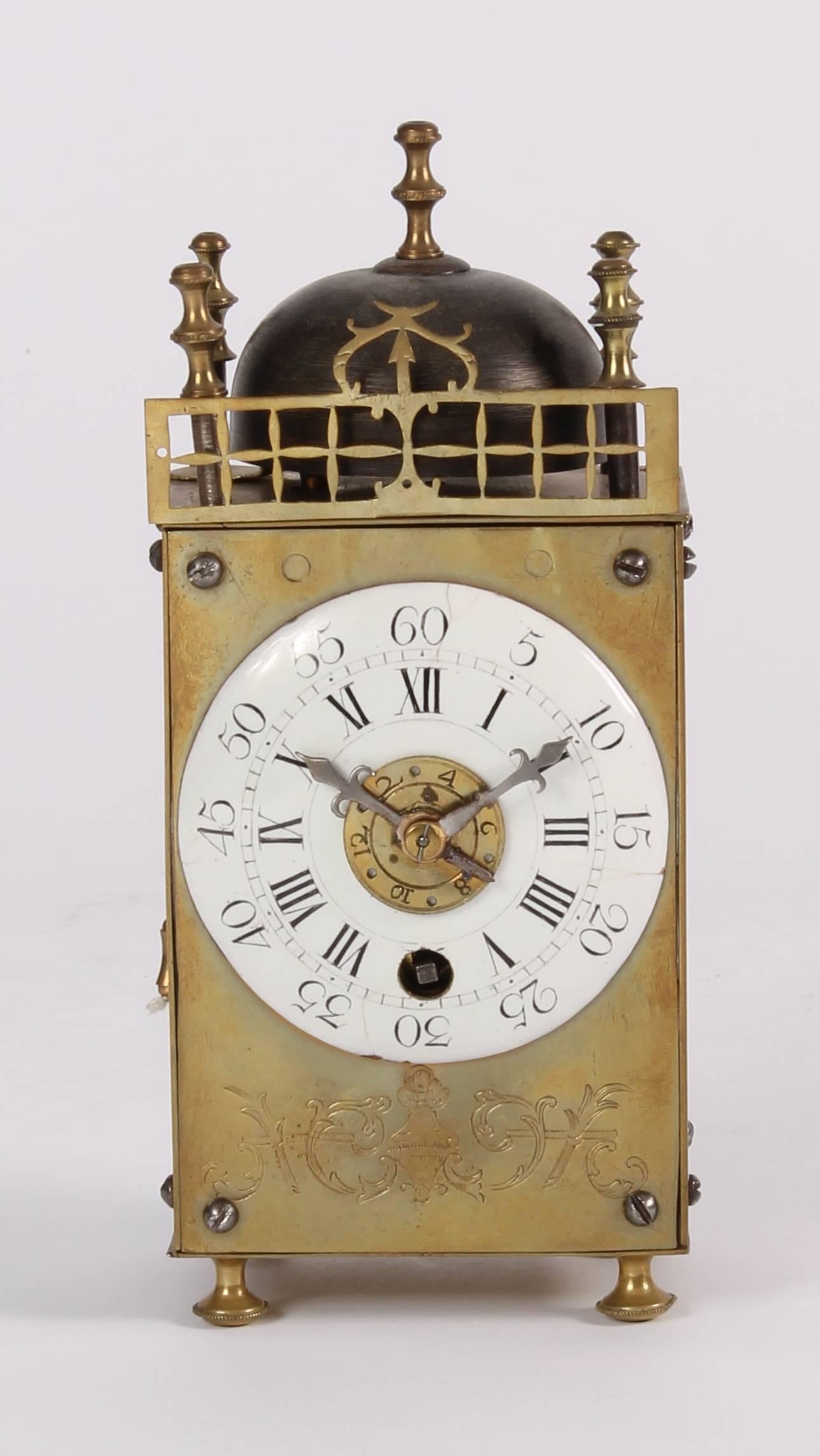 6 cm enamel dial with Roman numerals and five minute marking, iron hands and engraved alarm disc, 30-hour anchor movement with silk suspended pendulum and pull-wind alarm on a bell surmounting the brass case with pierced brass front fret and five