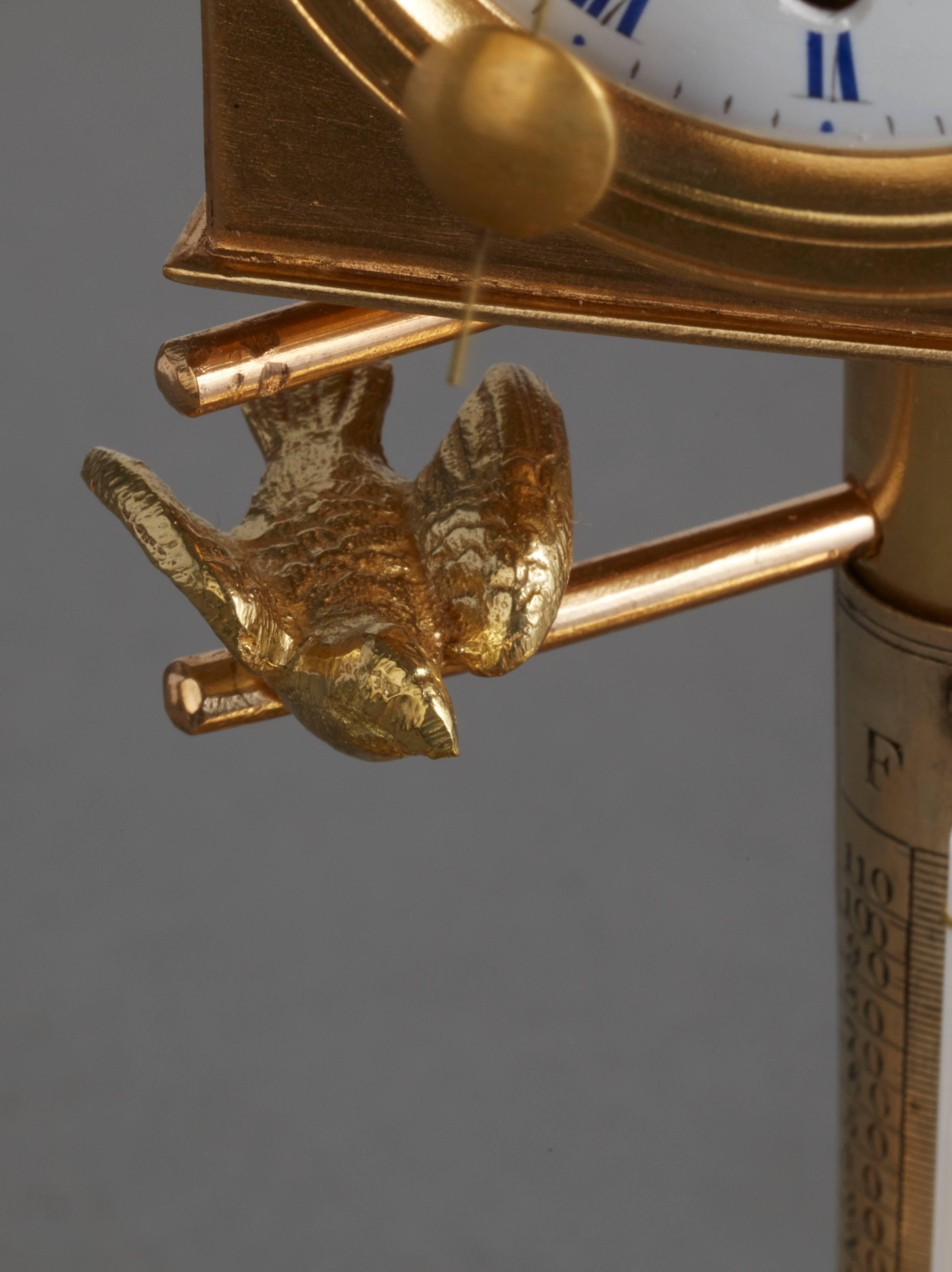 Desk inkwell with clock and ringing bell. The clock in the form of a bird case, two entrances for the birds on both sides of the clock sheltering the birds. The partly gilt and silvered bronze case. The fox trying to catch the birds on the base. On