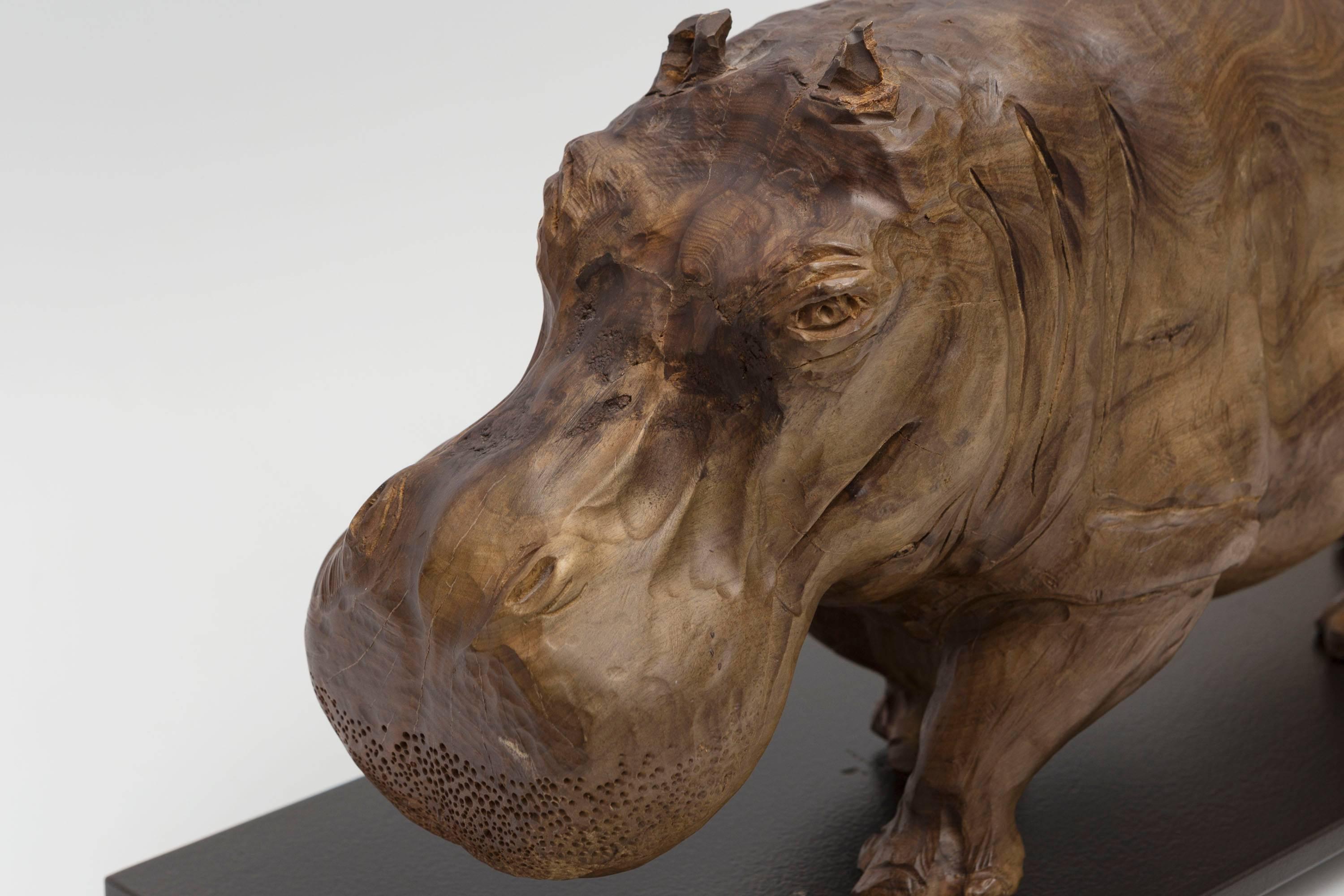 Solid wood Hippopotamus sculpture on a custom iron stand.