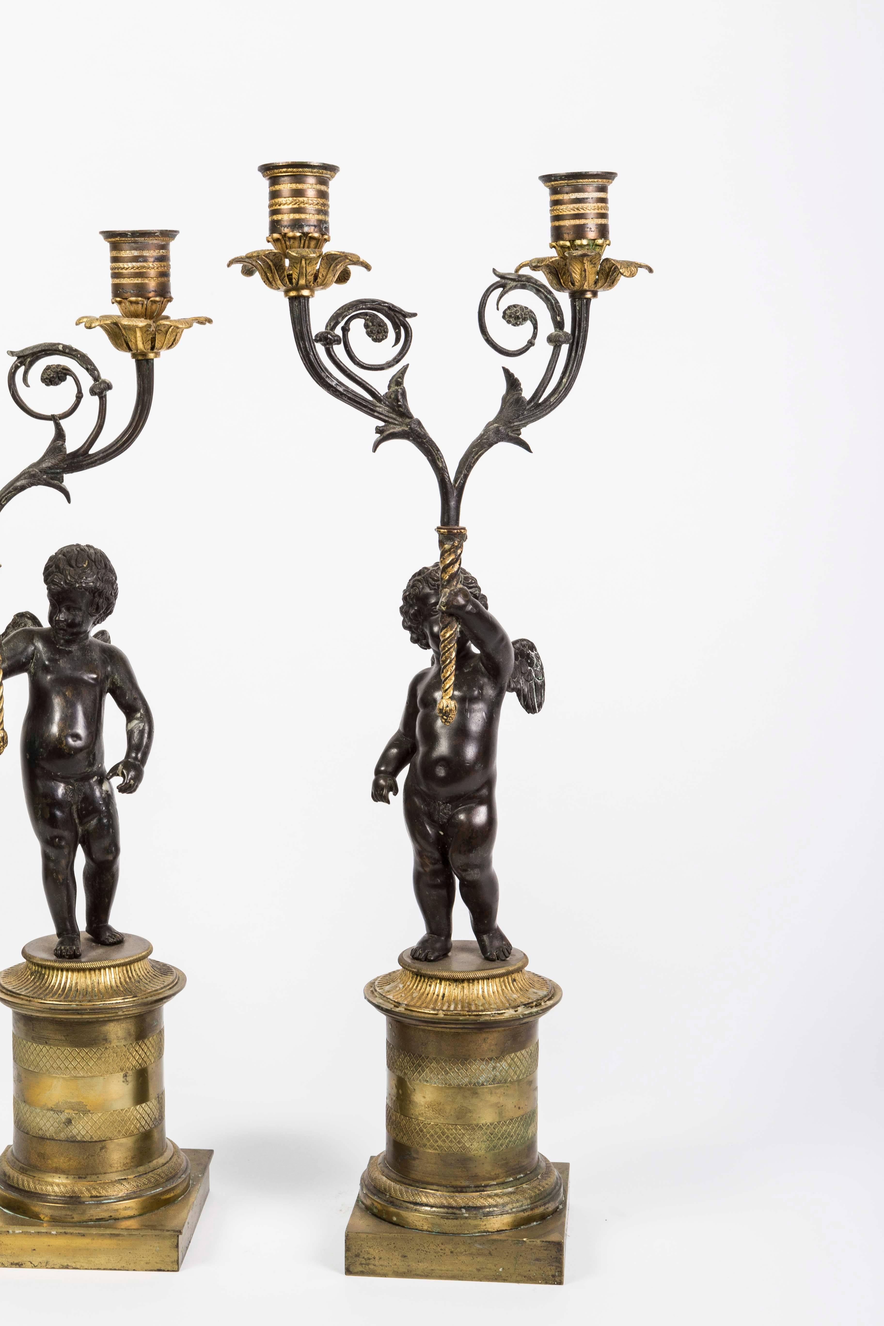 Pair of bronze doré cherub candlesticks in the Empire style.