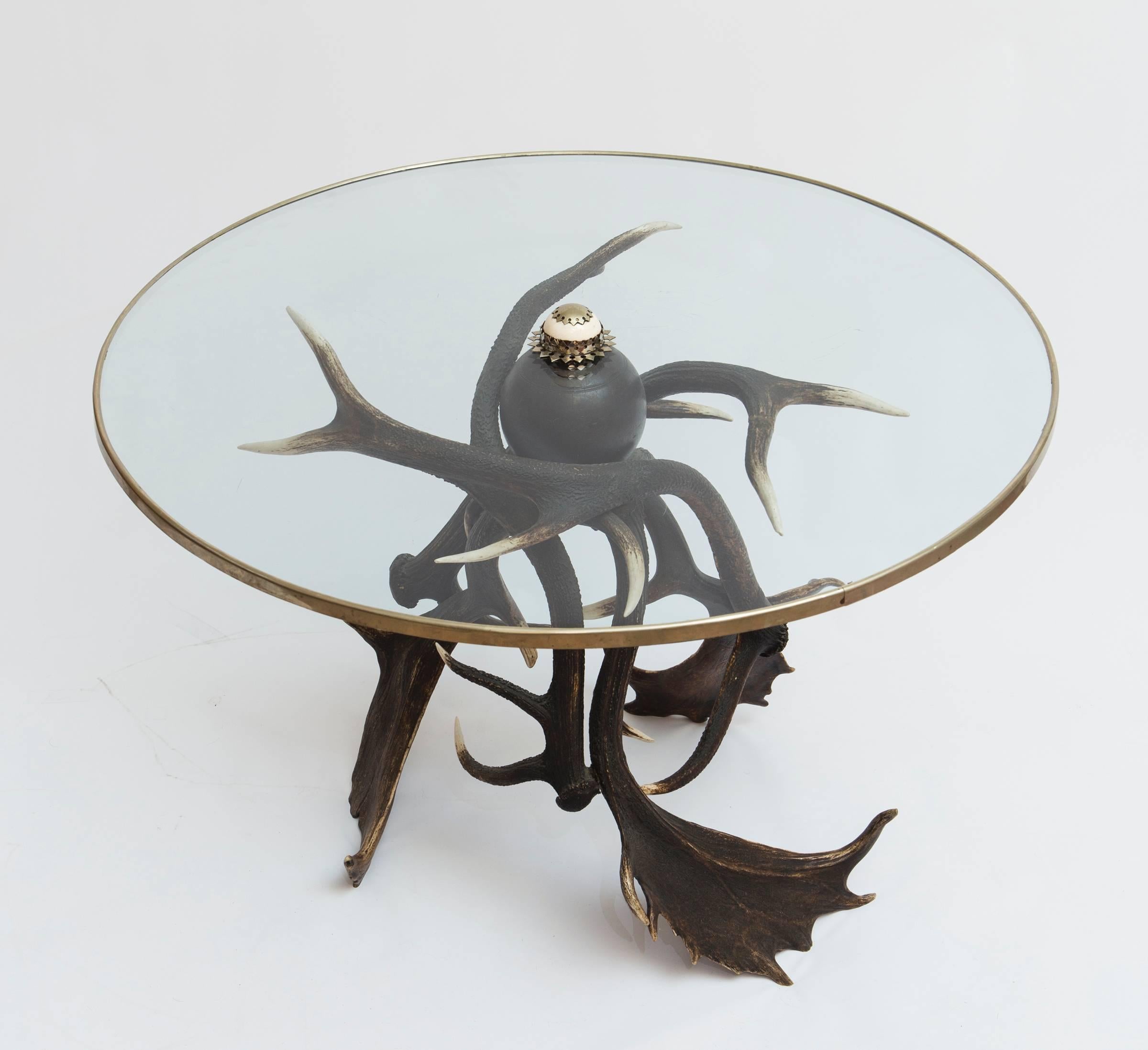 This is a unique antler based side table with a glass top with brass rim.  The table is beautifully made. 