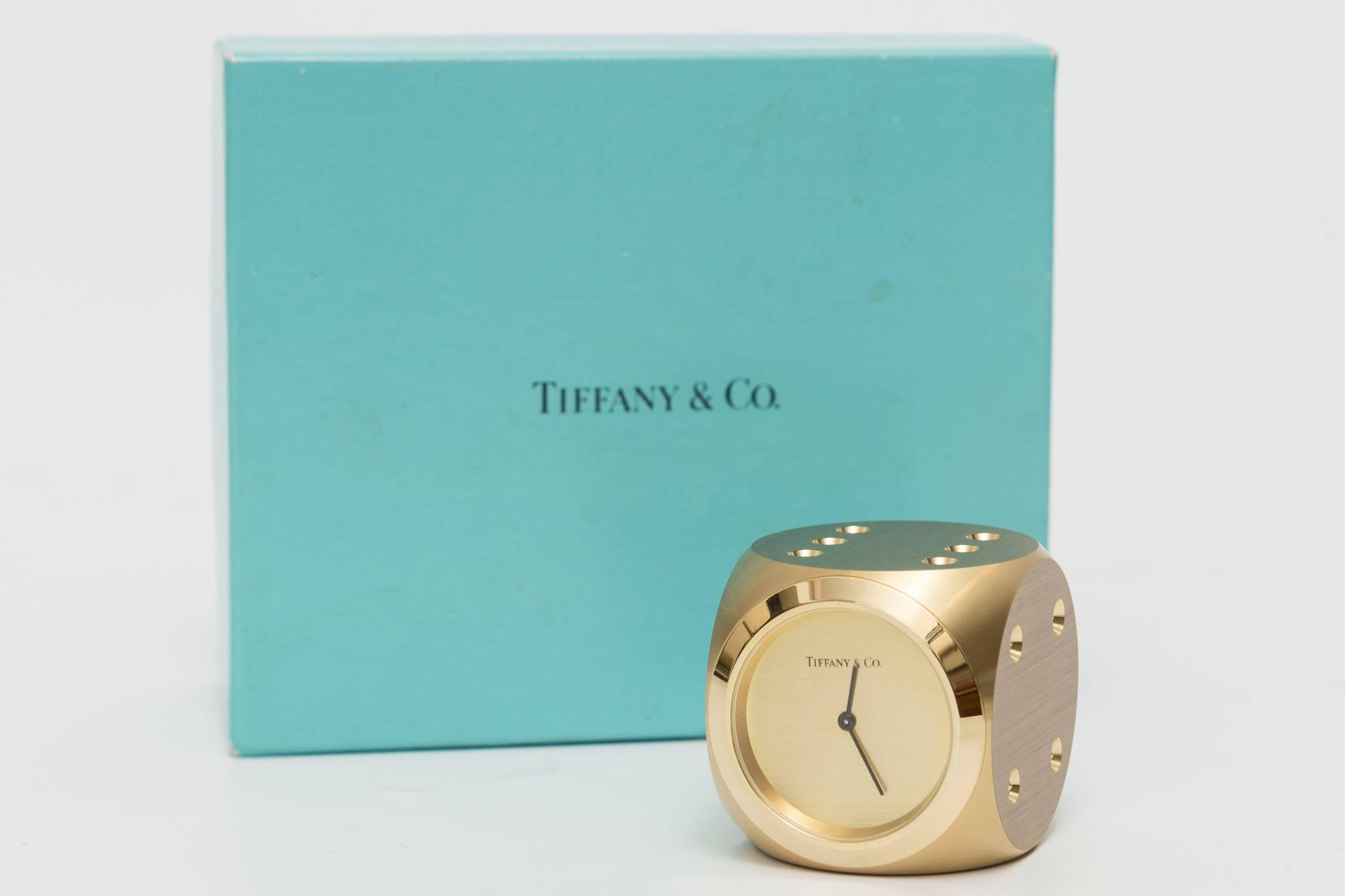 Tiffany & Co. bronze dice clock paperweight is shaped liked a dice with rounded corners and gilded finish having engraved holes on each side. In working order