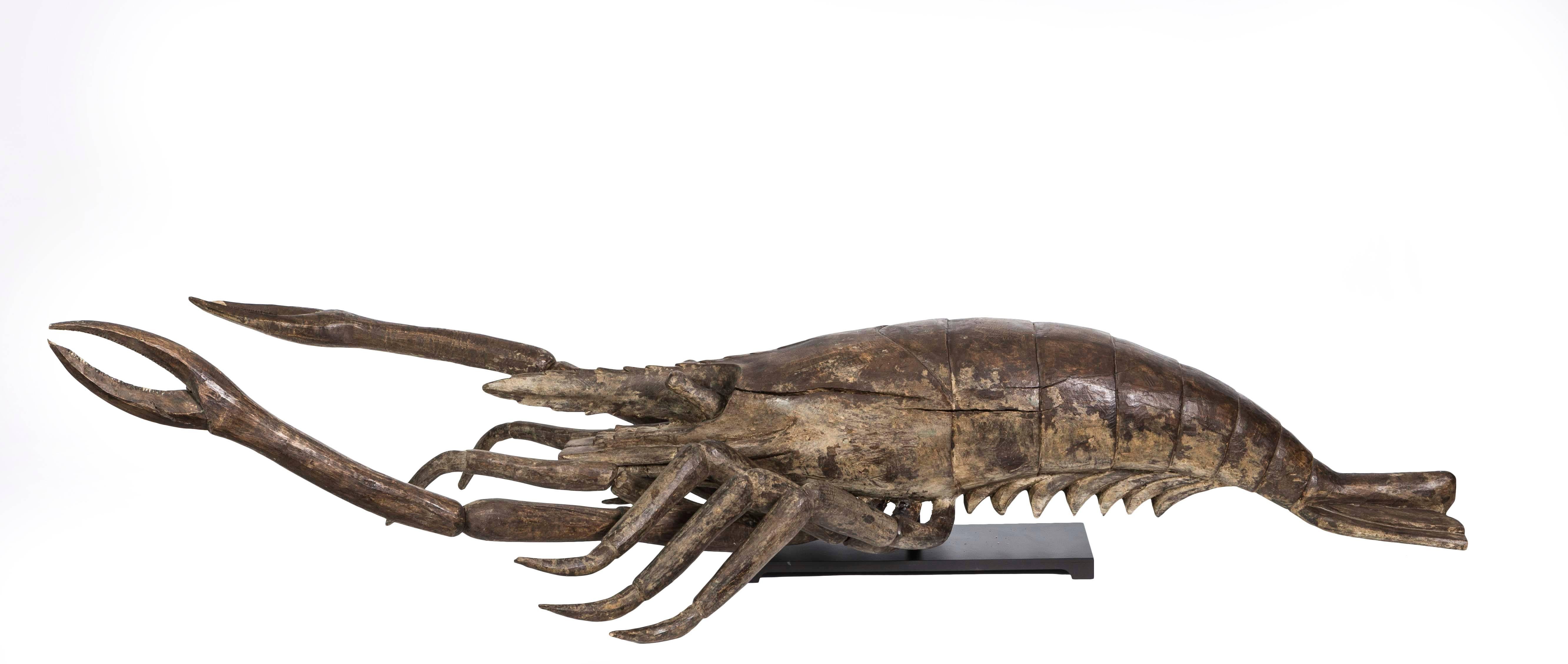 This large scale 19th Century Folk Art articulated wooden carved lobster/shrimp crustacean sculpture is very unique and unusual.  The lobster is mounted on a custom iron stand made to hold the legs and tentacles  a couple of inches off a table. This