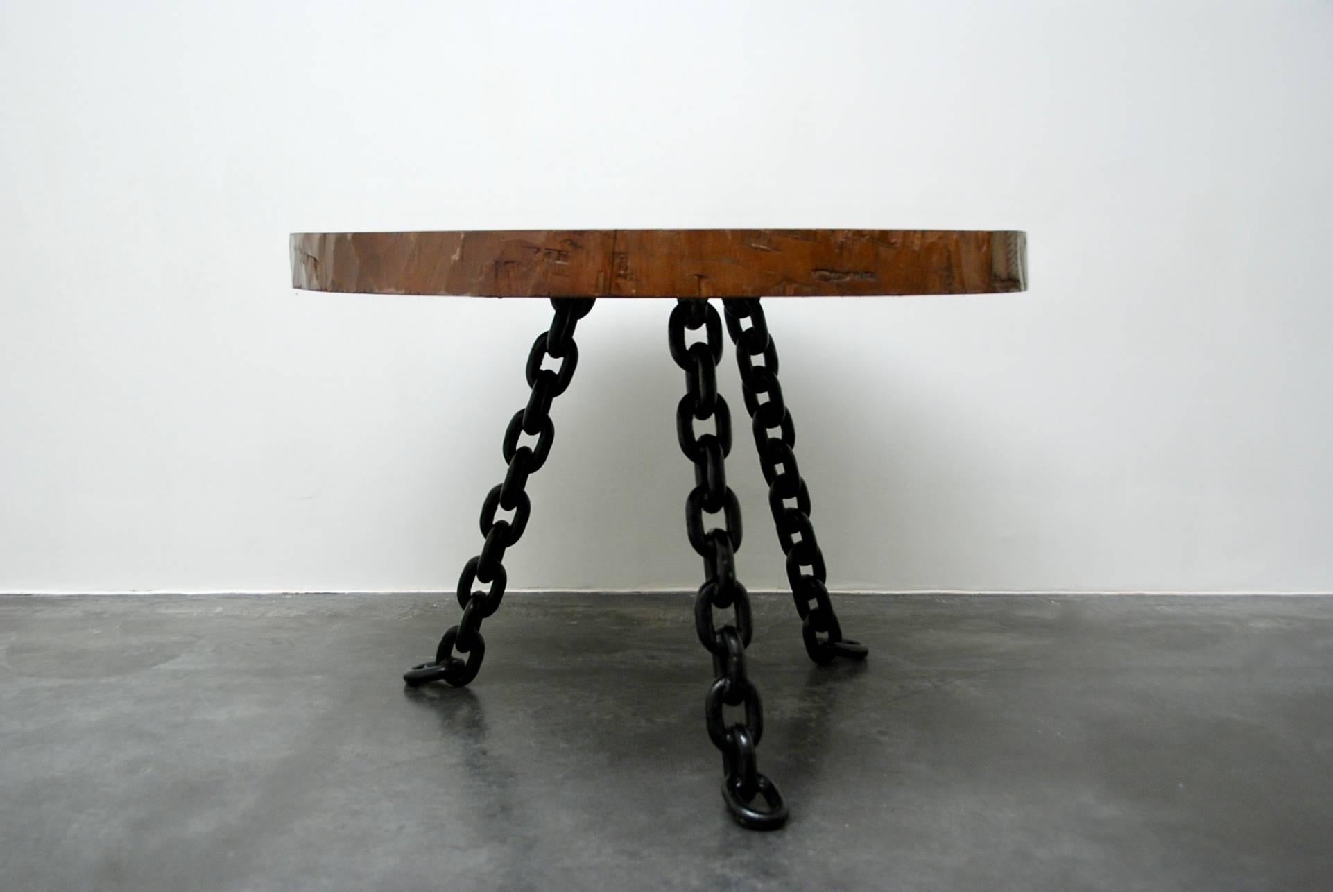 This impressive dining table can be dated in the 1940s or 1950s
The three legs are made of heavy black lacquered metal chains. The top is an amazing slice of tree trunk. It is an old dining table in very good original condition, this extraordinary