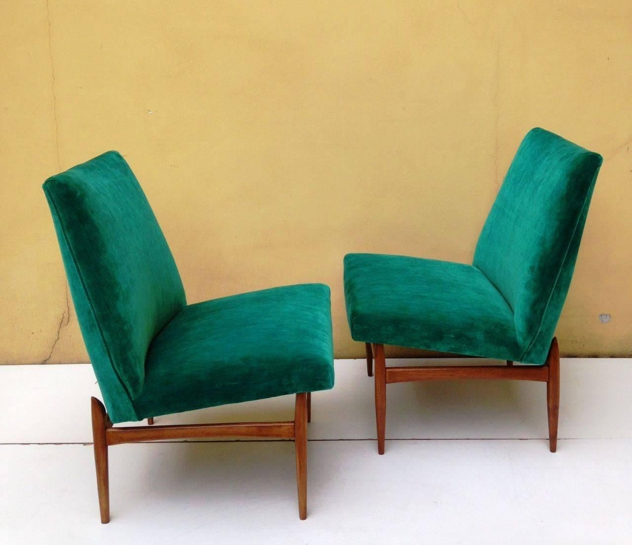 Sleek pair of chairs in green fabric.
