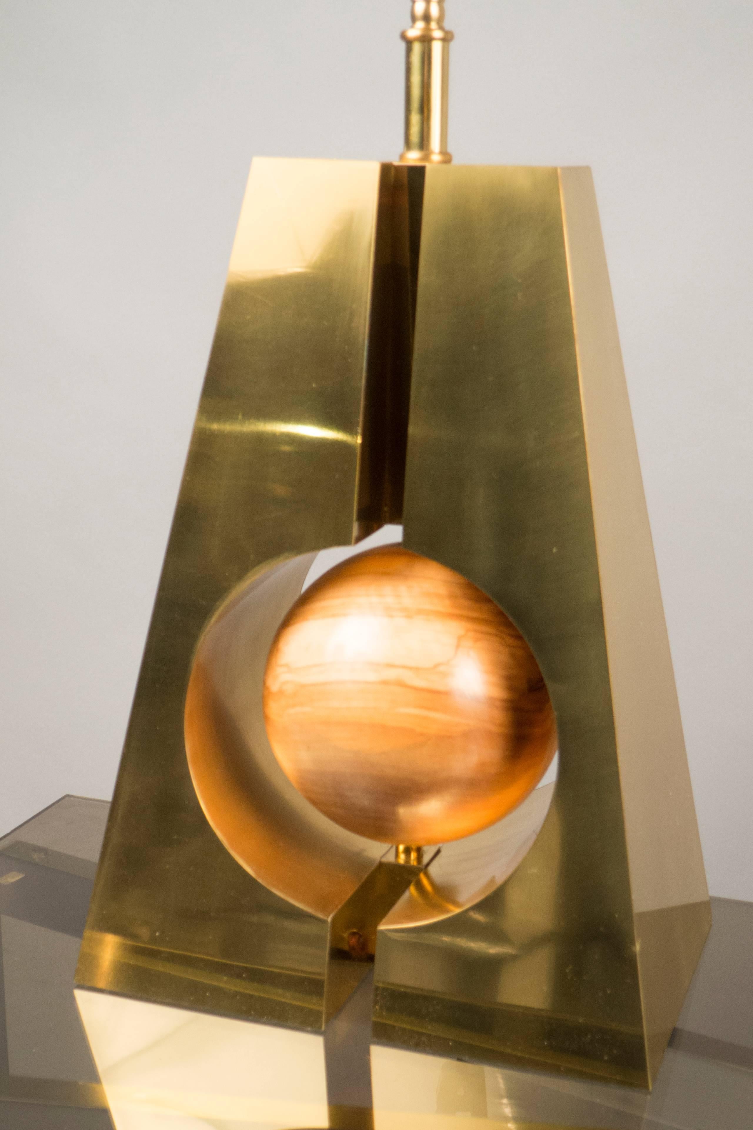 Wood spheres are suspended in unique brass structures and topped with rectangular eggshell linen shades.



 