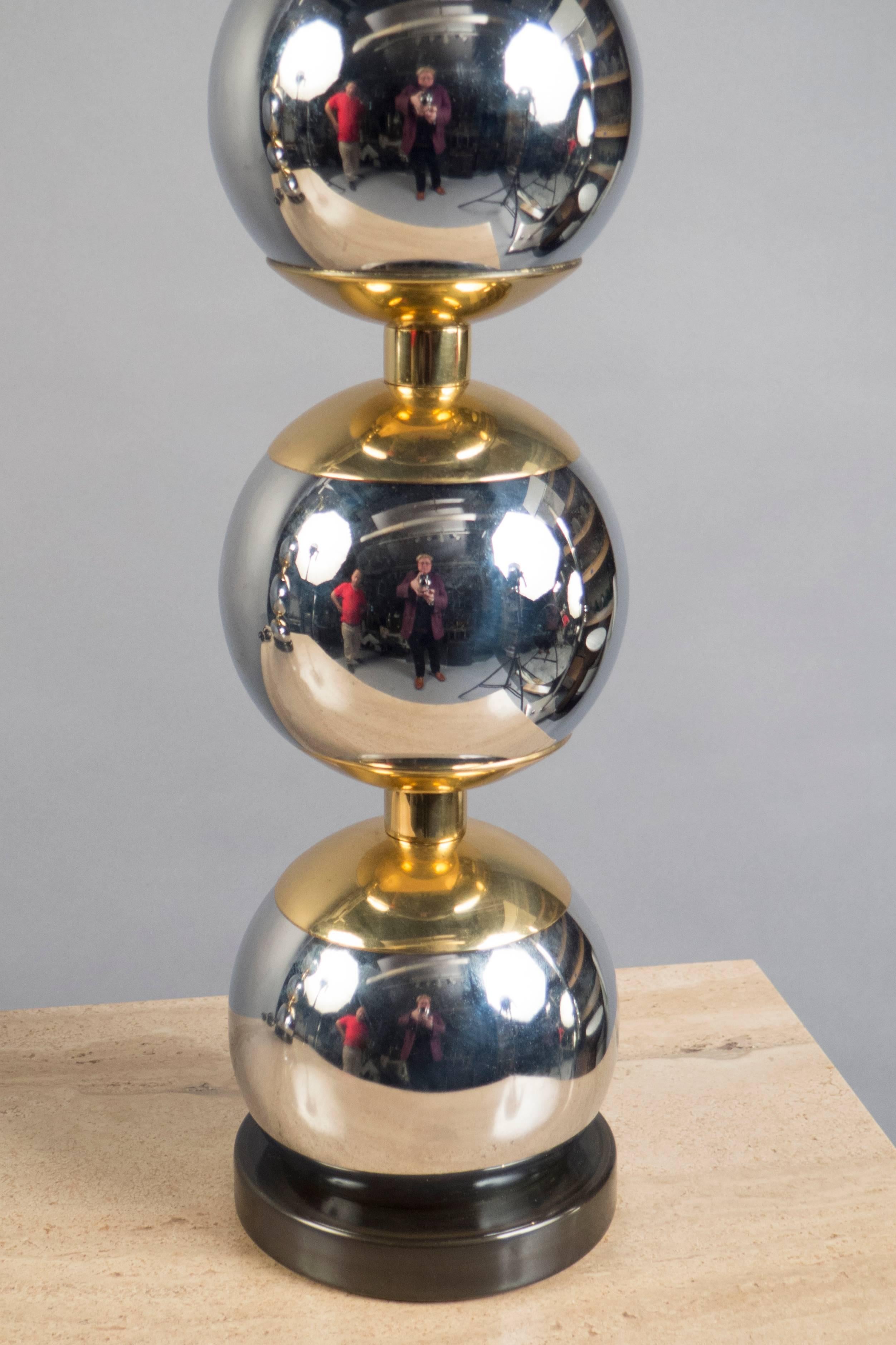 Each lamp composed of three polished chrome and brass spheres, raised on a patinated brass base.
 
(Lamp shade not included)
