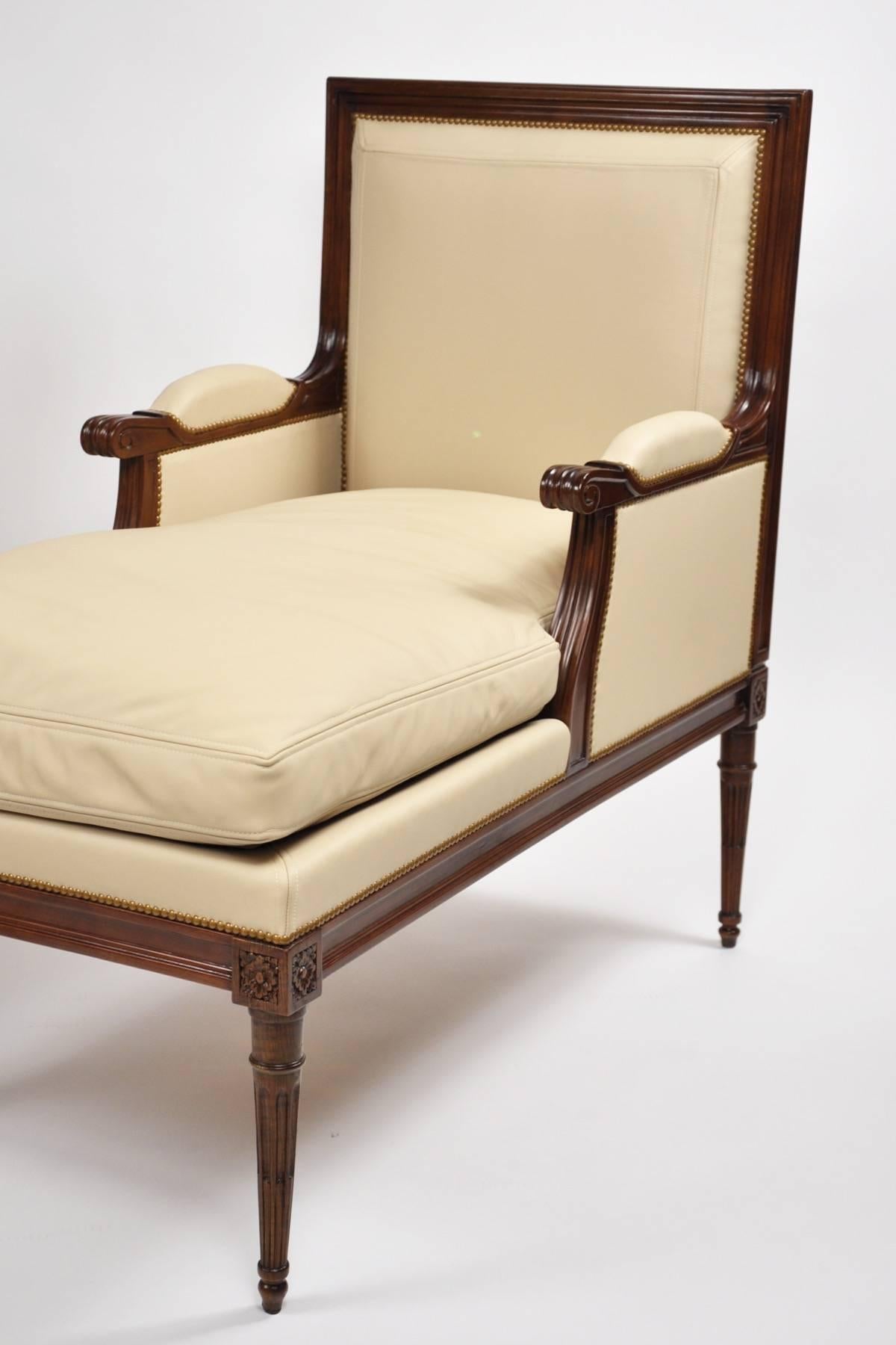 Carved beech armchairs with elongated seats in the style of a Louis XVI “Duchesse”; handsomely carved with rosettes and scrolls; upholstered in leather, with padded rests and a long cushion seat. Arm height 25-3/4”.

OUR REFERENCE N5575
 