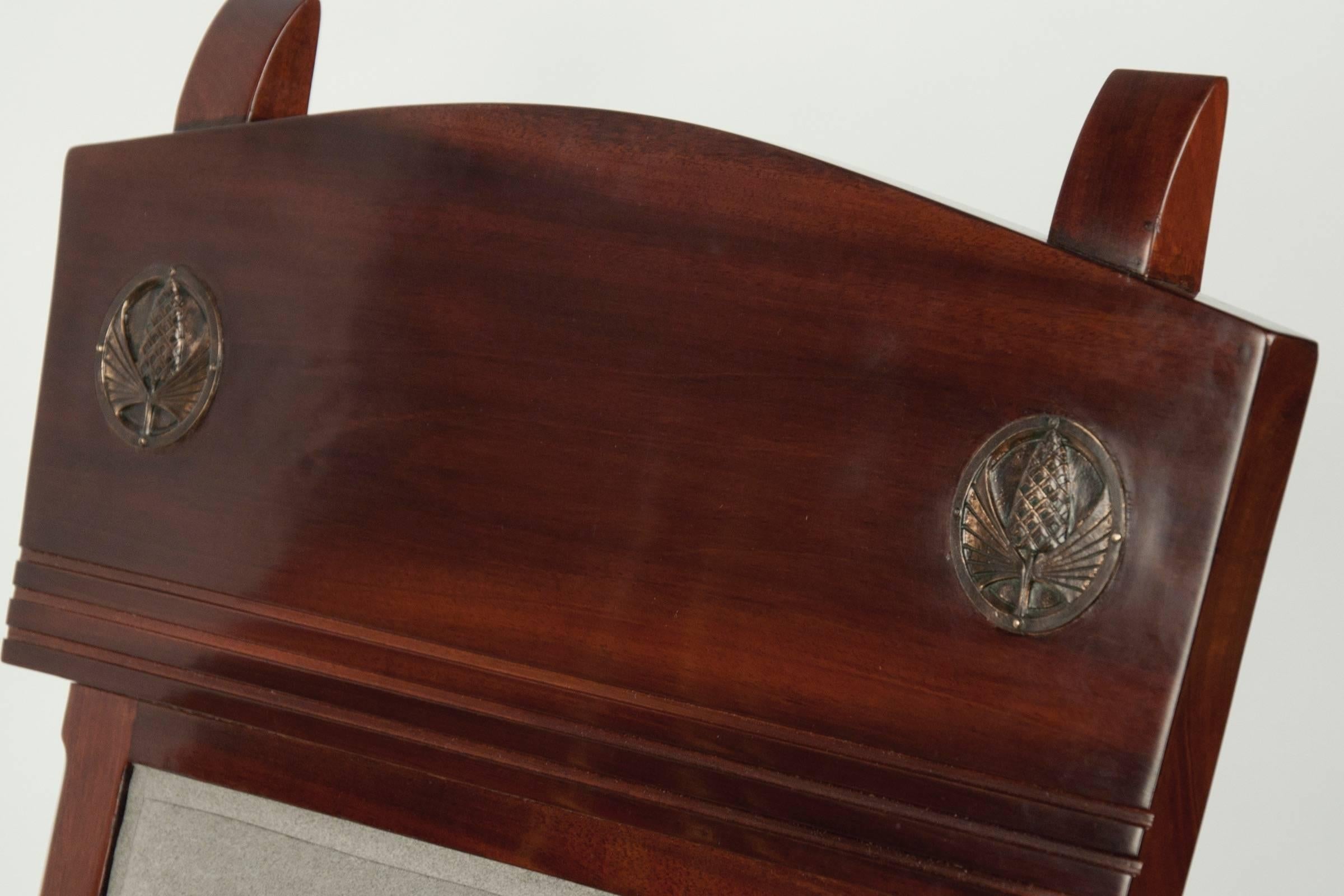 Low curved walnut frame, carved with straight grooves along the back and inset with two bronze plaques decorated with a pine-cone motif. Signed.
  
OUR REFERENCE N6489
 