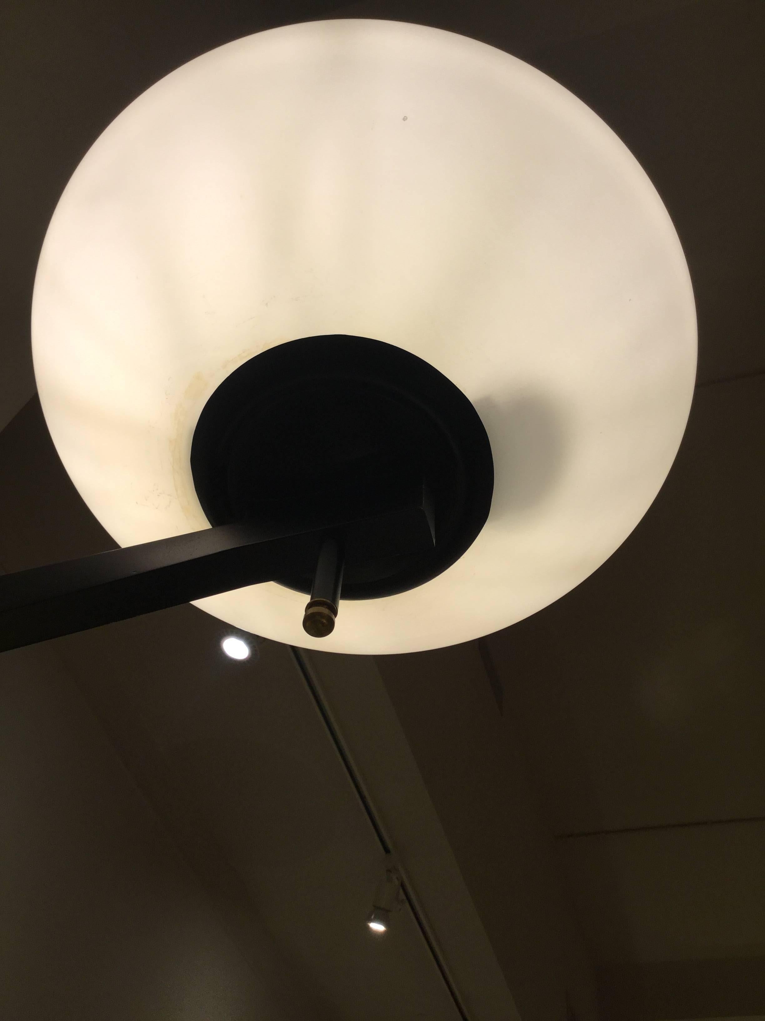 Each wall light composed of a black enameled metal bracket holding a round white glass shade on a horizontally extended arm.

OUR REFERENCE N10094