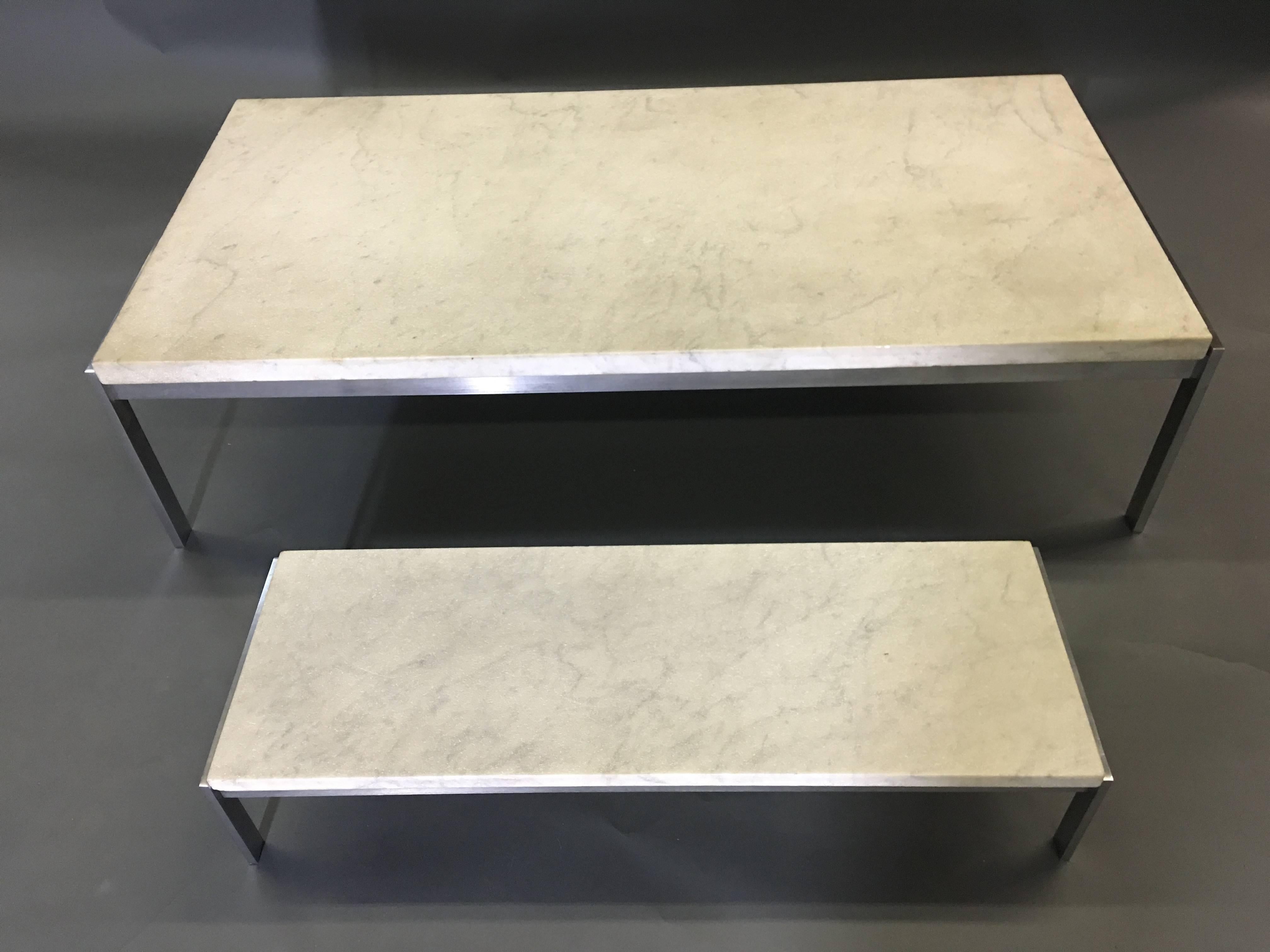 White rectangular marble tops inset into stainless steel bases marked 