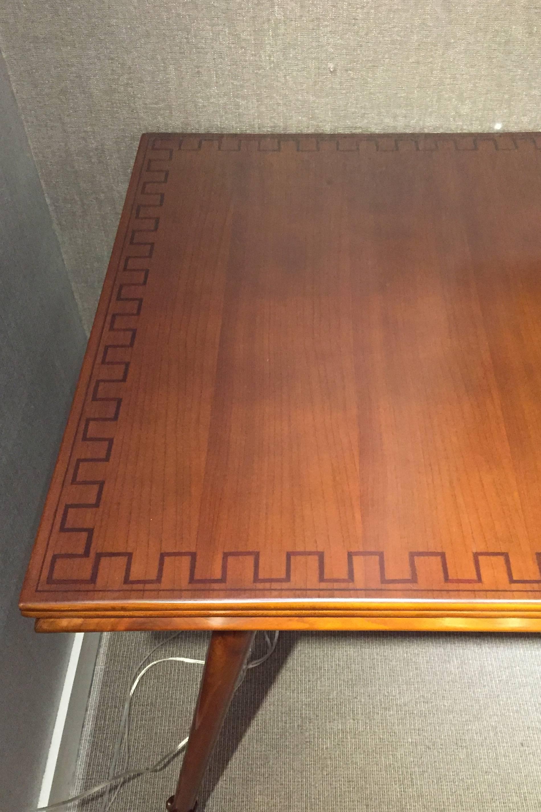 Rosewood and fruitwood. Rectangular table with a finely carved molding that runs the apron, raised on round and tapered legs, terminating in carved foliate feet. The table top is inlaid with a meandering pattern of tinted wood.

OUR REFERENCE