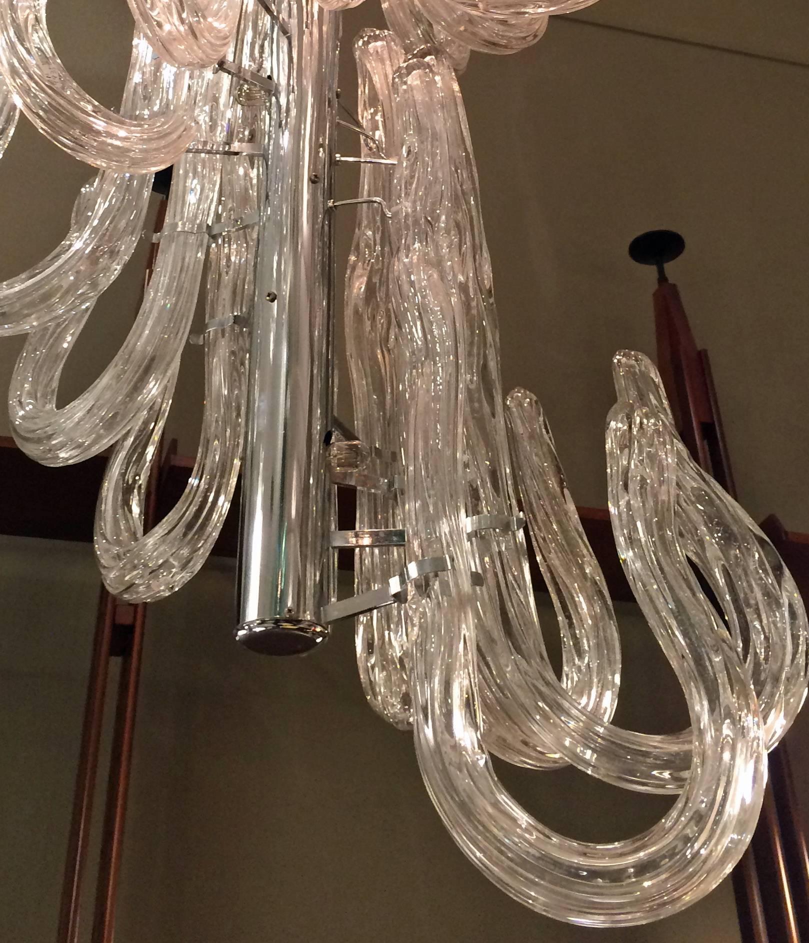 Clear glass elements in the shape of canes hung upside down on a nickel-plated rod.

      


