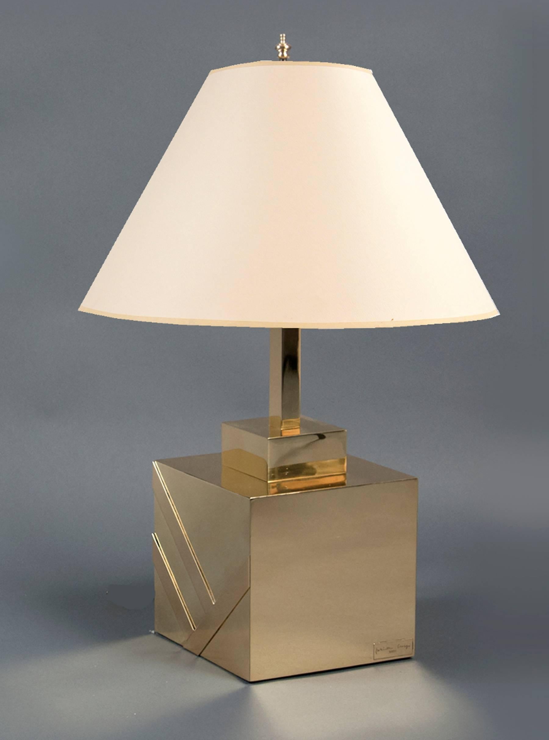Polished brass cubic base over a wood core, the brass decorated with a diagonal design. Height (with shade): 34