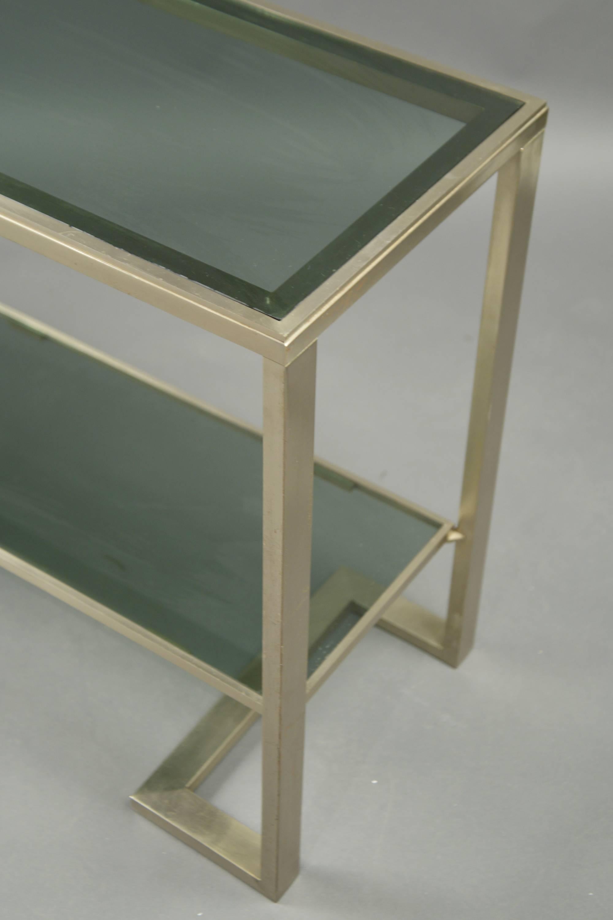 Steel two-tier console with each tier featuring a gray tinted glass top.
 