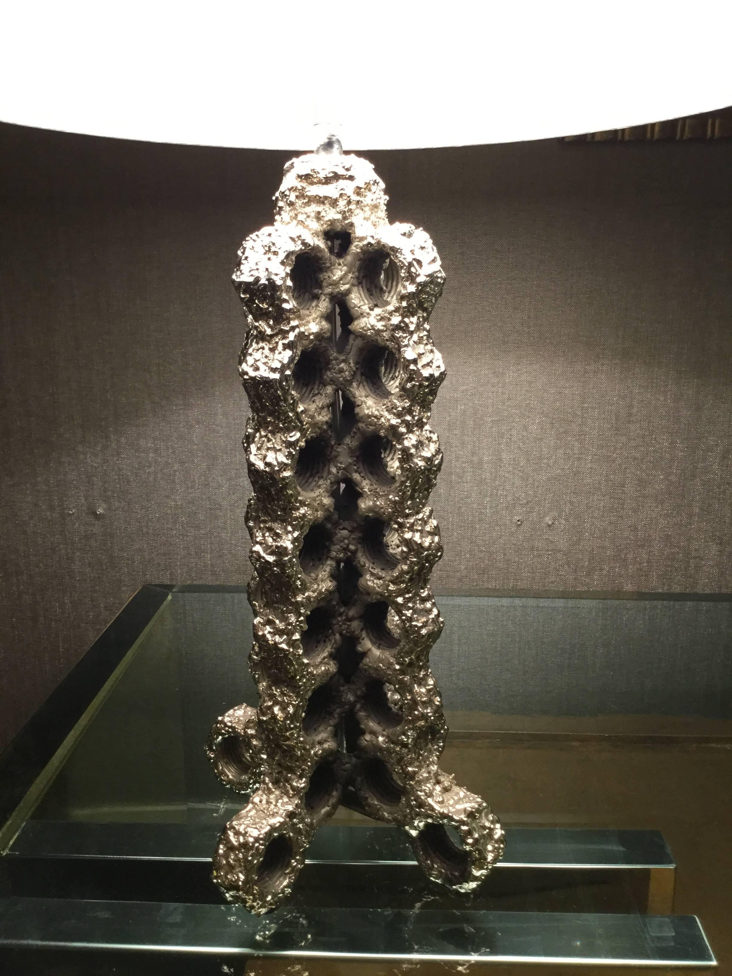 Antiqued silvered-bronze shaft composed of numerous threaded bolts welded end to end. Signed “Chauvat” on one of the four out-splayed feet.

(Lamp shade not included)