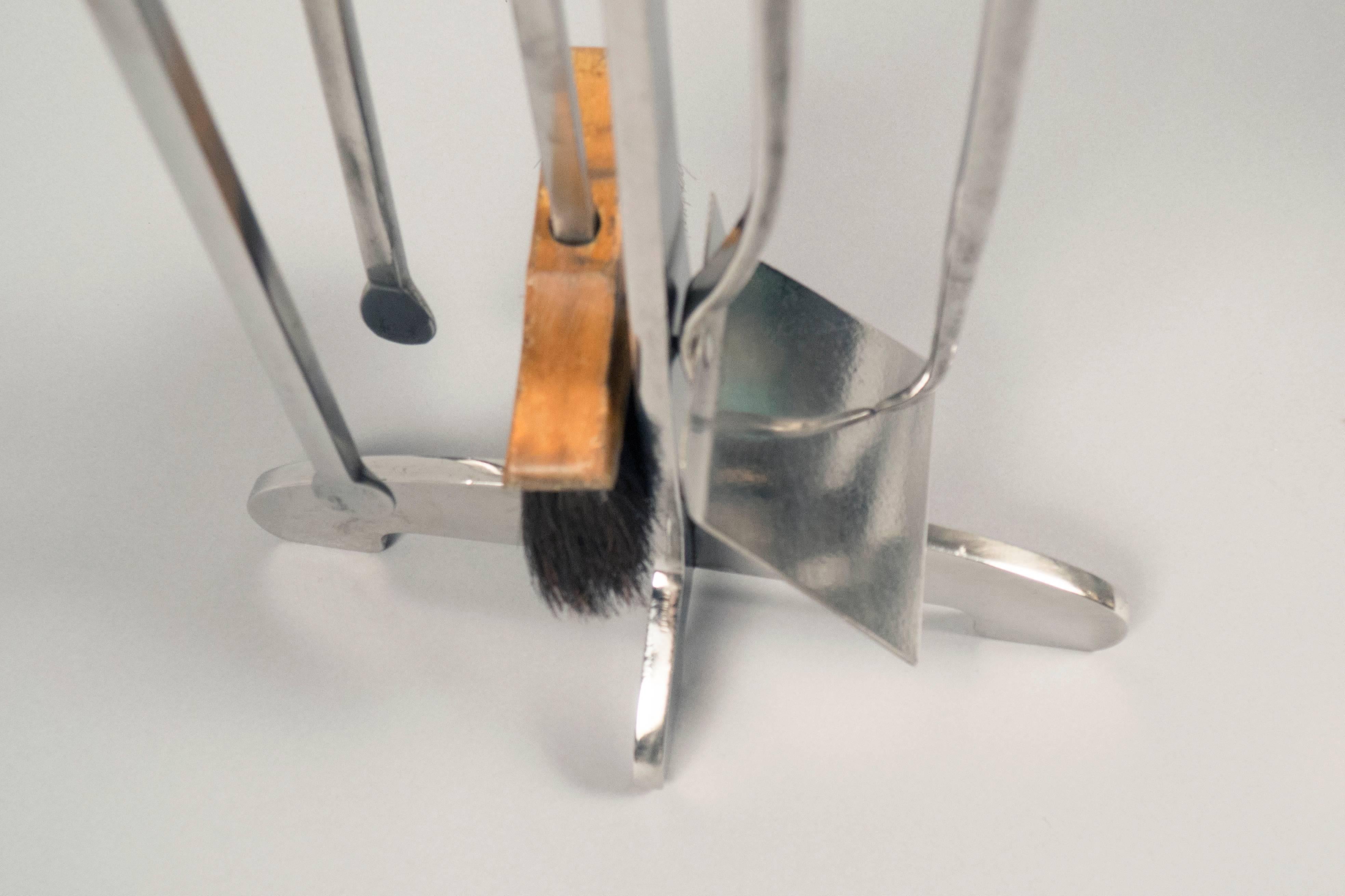 Polished steel fire tools with rounded heads. The set consisting of a shovel, tongs, poker and wooden brush arranged on a stand.


  
