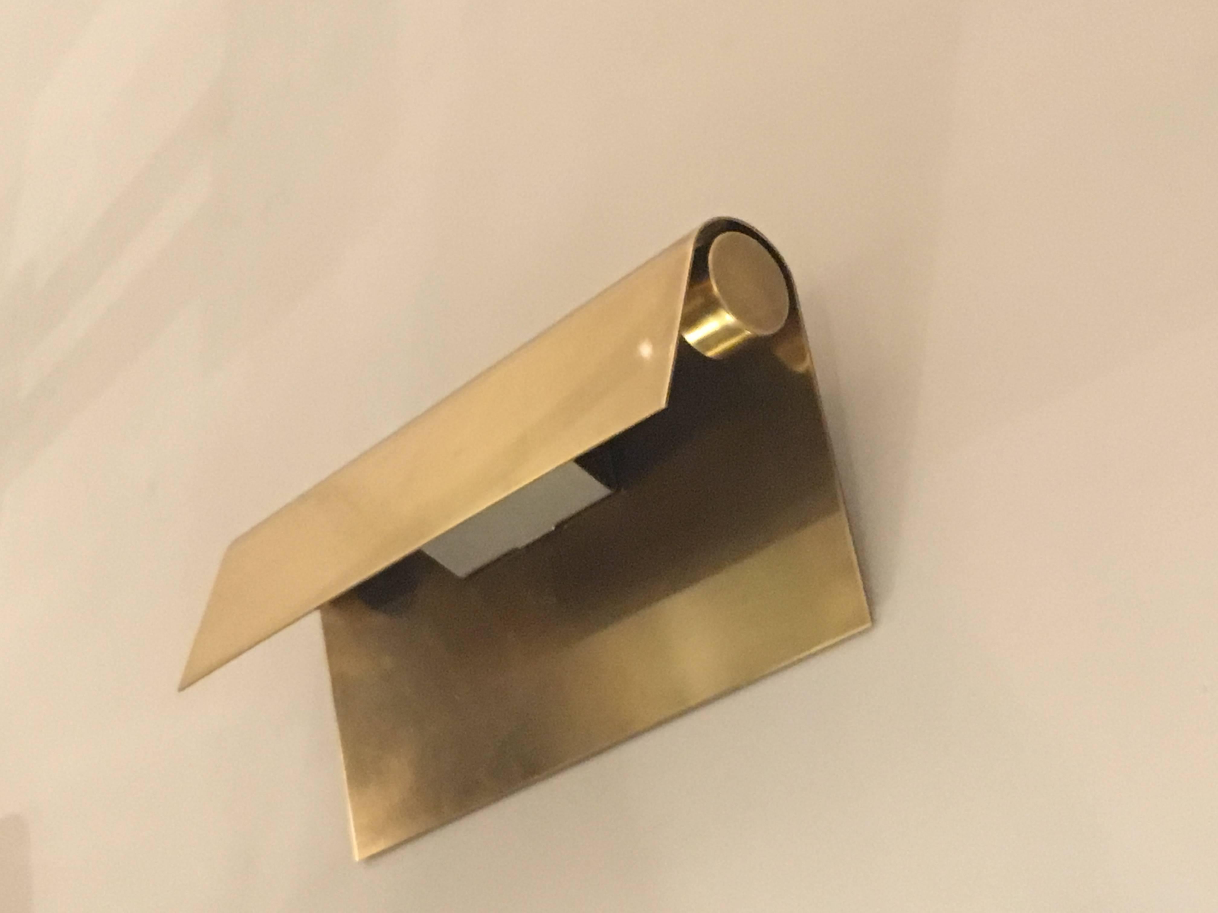 Pair of polished brass sconces, consisting of a brass sheet, folded over the socket system on the top.
   